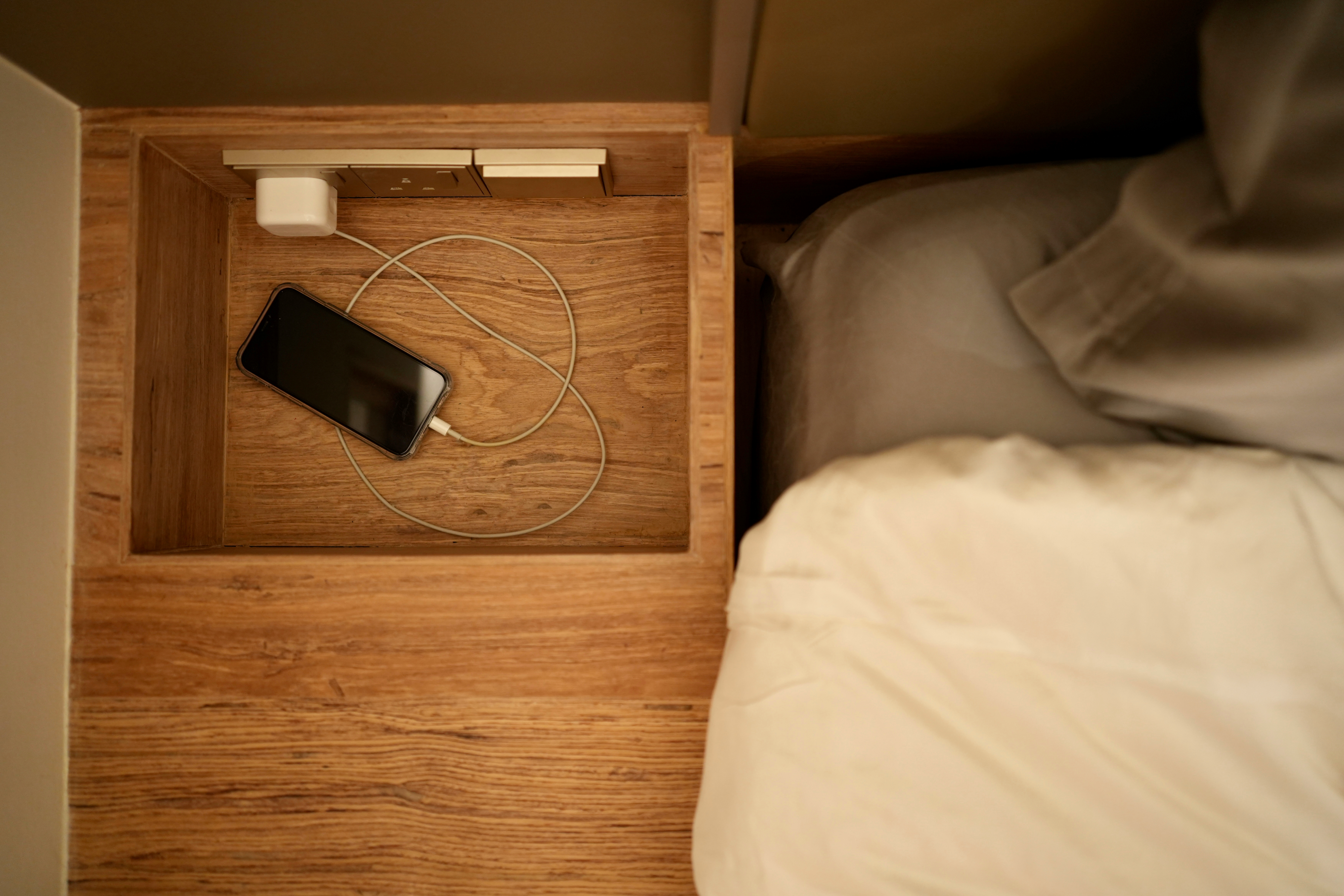 Our Bedroom: Zen from a Modern Japanese Perspective - Wooden drawer, smartphone, charging cable, bedside table, wooden floor