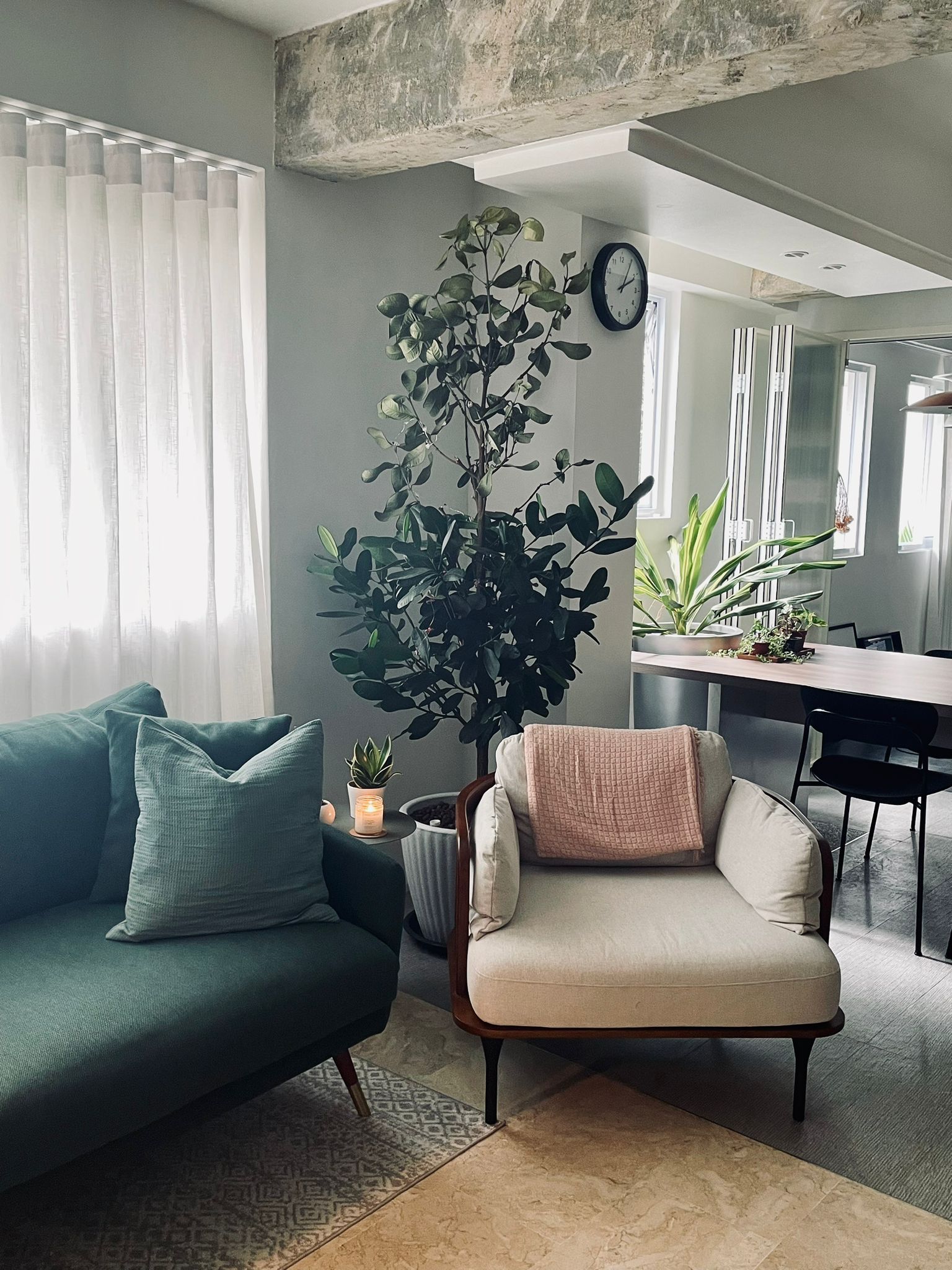The living room - an intimate space for conversations and more! - Green sofa, beige armchair, indoor plants, modern decor