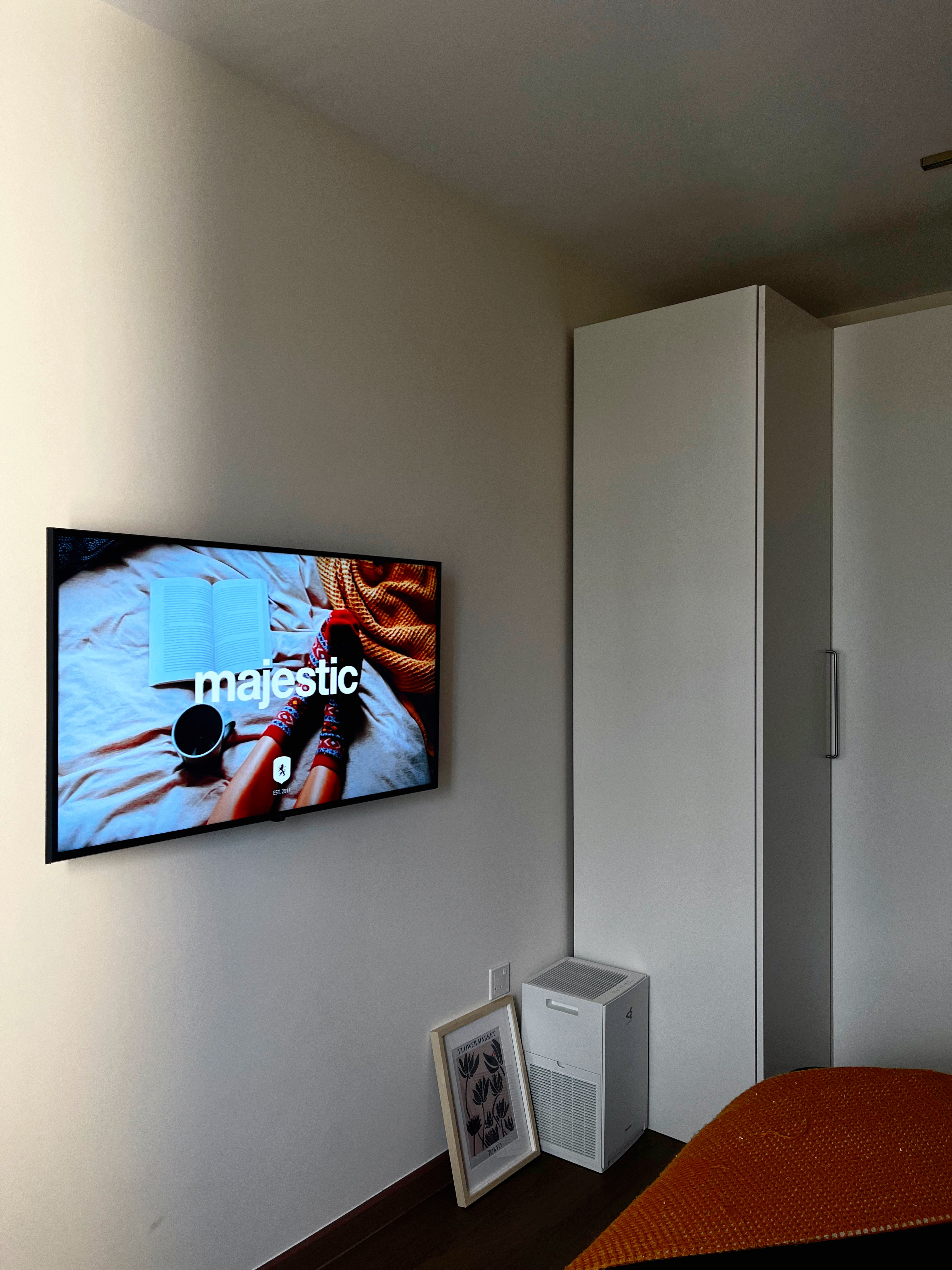 Our bedroom: A cosy escape into slumber  - Minimalistic living room with modern decor, Wall-mounted television displaying