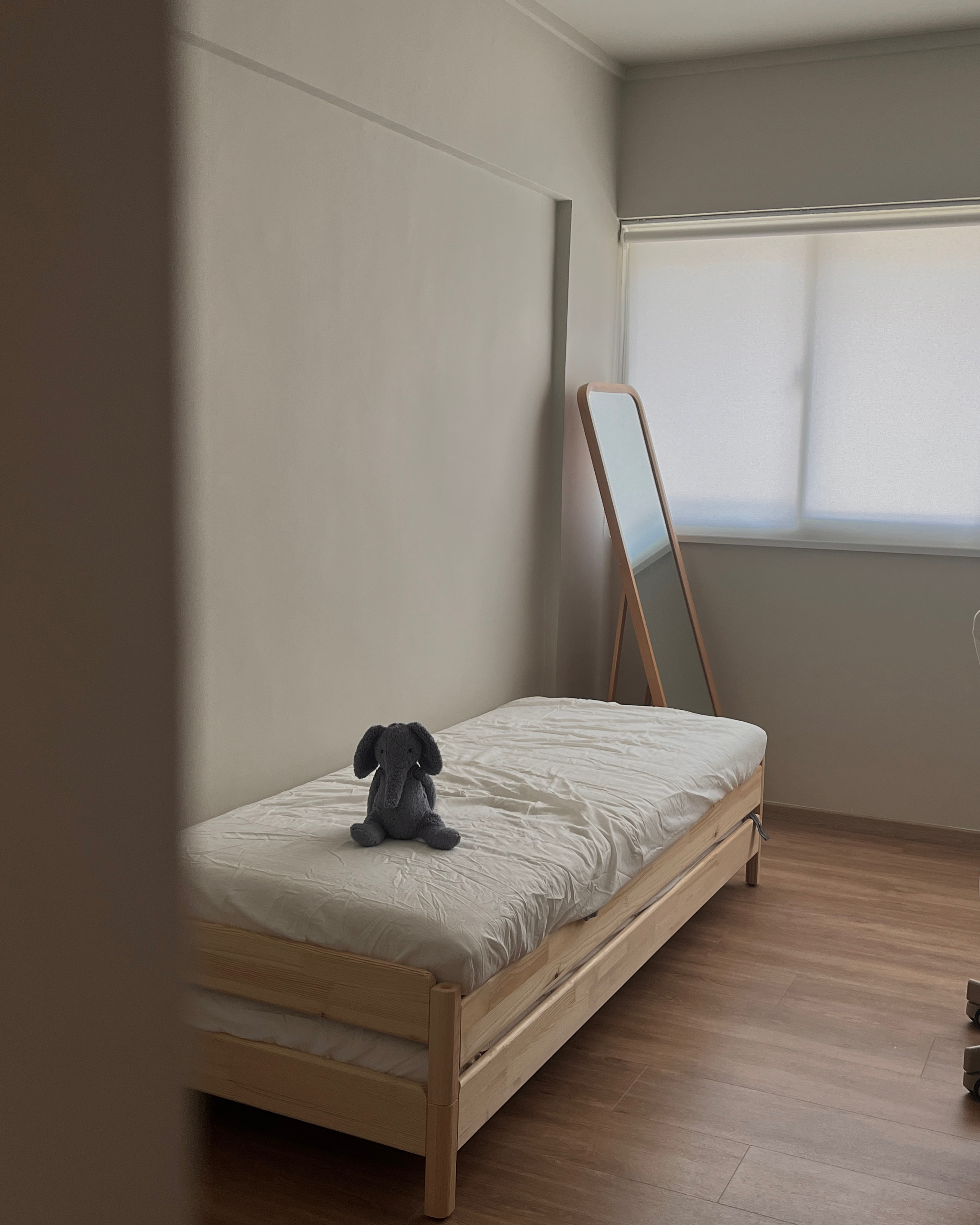 Multi-Functional Space: The Workspace Guest Room - Wooden bed with white mattress, gray stuffed elephant toy on top