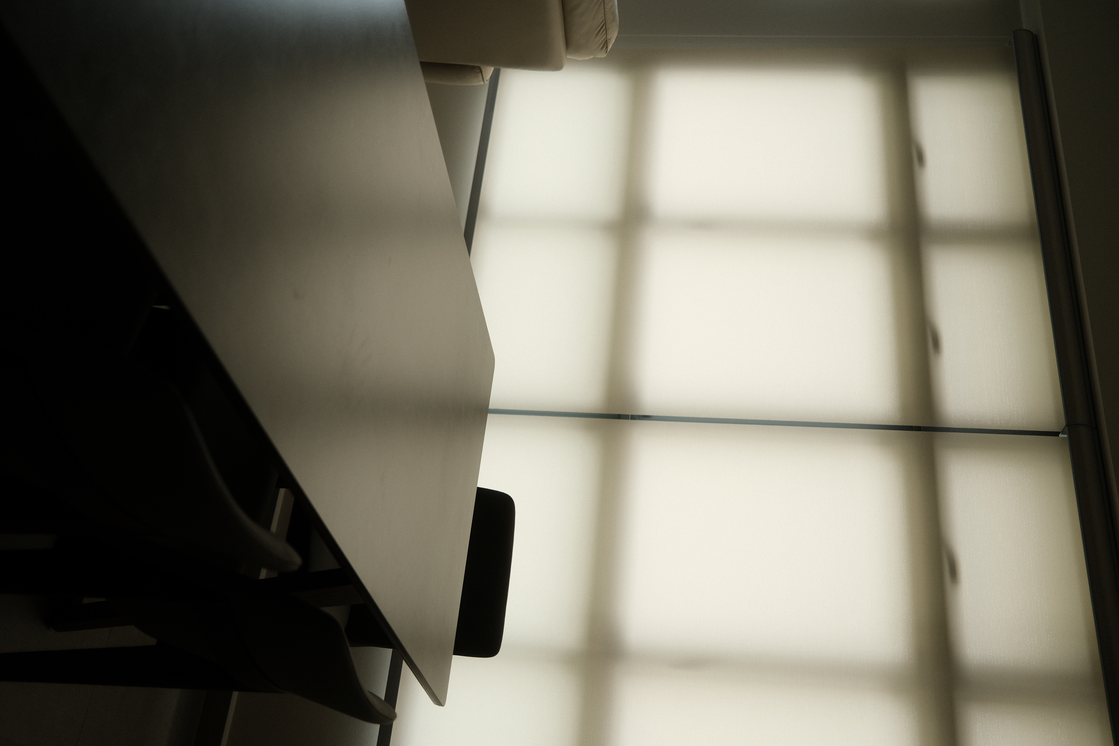 Dining space: Weaving conversations between meals - Modern minimalist desk, soft ambient light, geometric window, grid