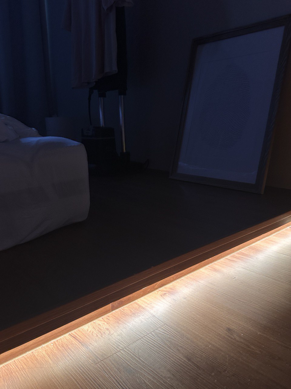 Minimal Bedroom: Our place to unwind and relax  - dimly lit room, wooden floor, soft lighting, bedside table, framed picture