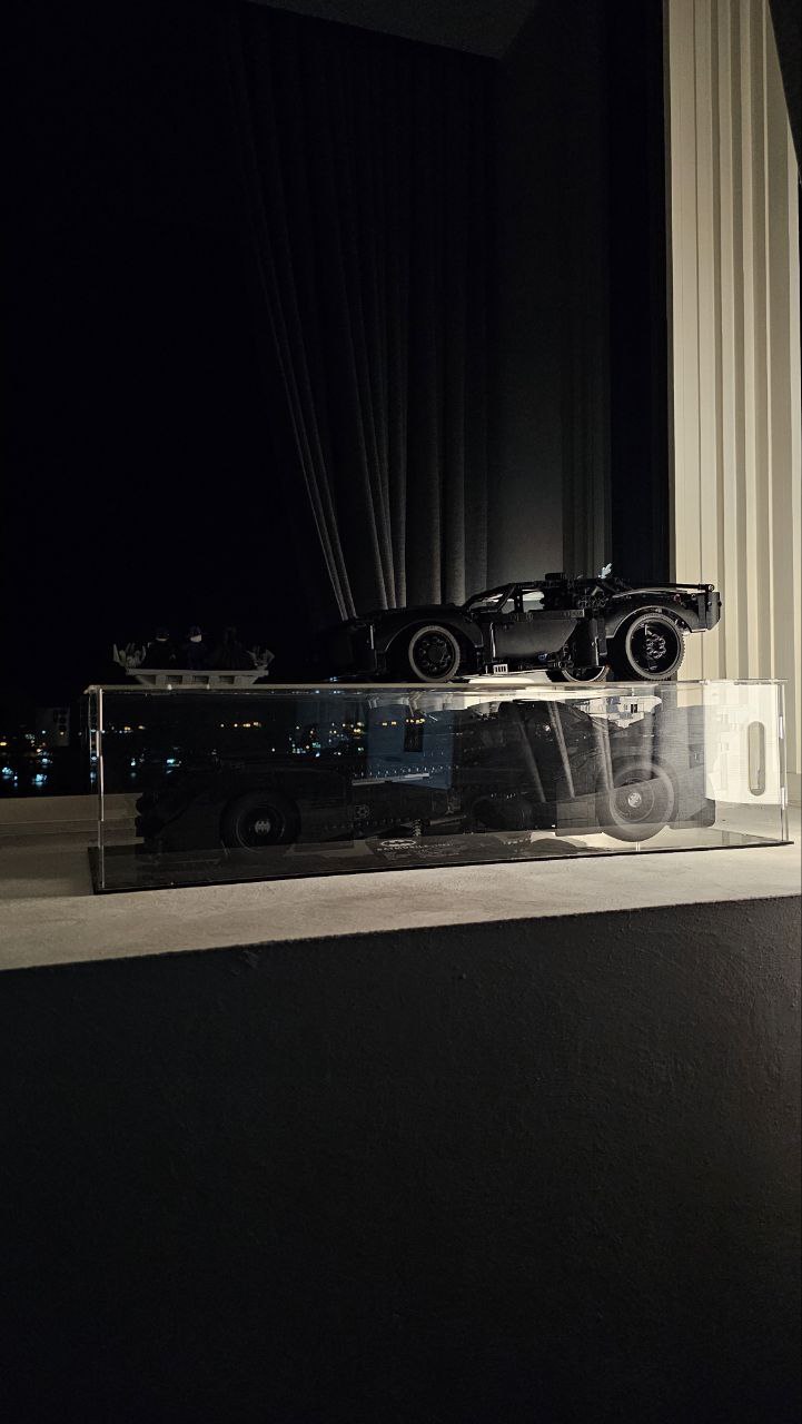 Simple Bedroom for us and the Sandman - Nighttime display featuring a black LEGO Batman car model, Transparent display case