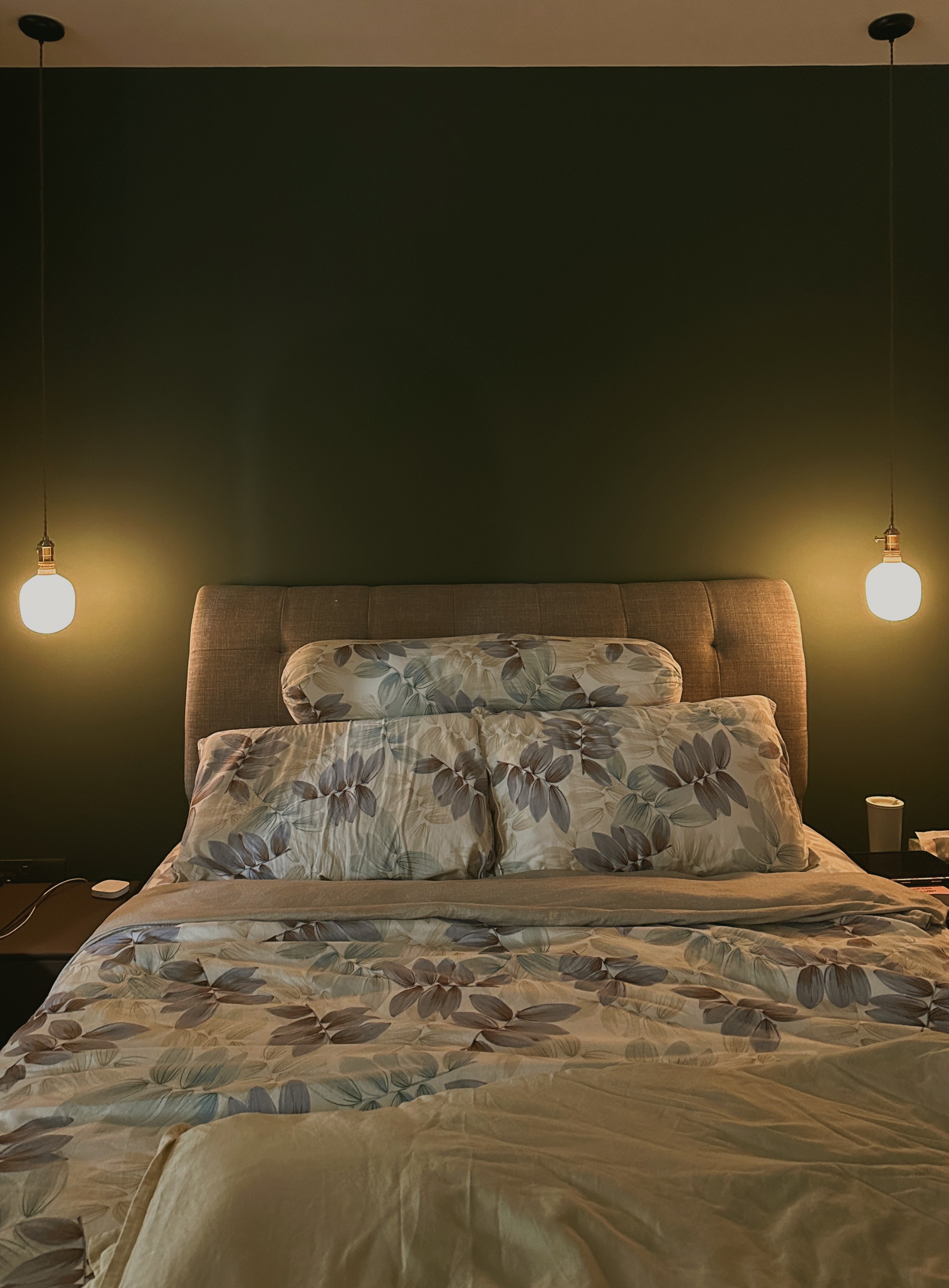 Our Bedroom: Can't get any bed-ter than this  - Floral-patterned bedding, modern headboard, warm lighting, cozy bedroom, soft