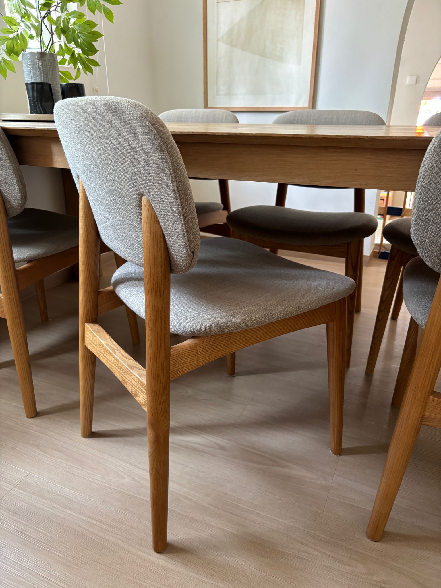 Our dining area - the heart of the home.  - Wooden dining table, gray upholstered chairs, minimalist design, natural wood