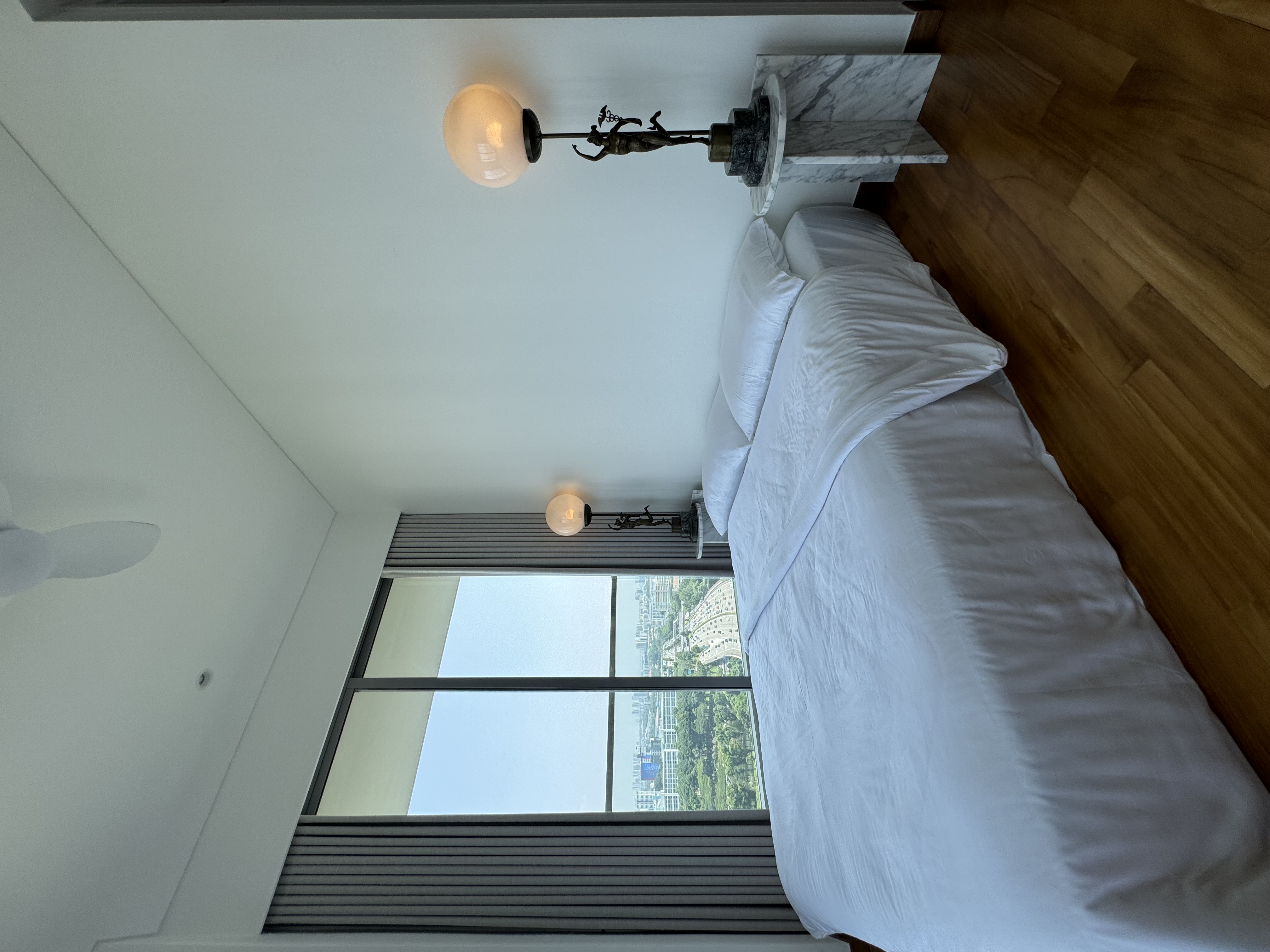 La-La Land @ Rumah Beacon - Modern bedroom with large windows, white bed with neatly made bedspread, elegant ceiling light
