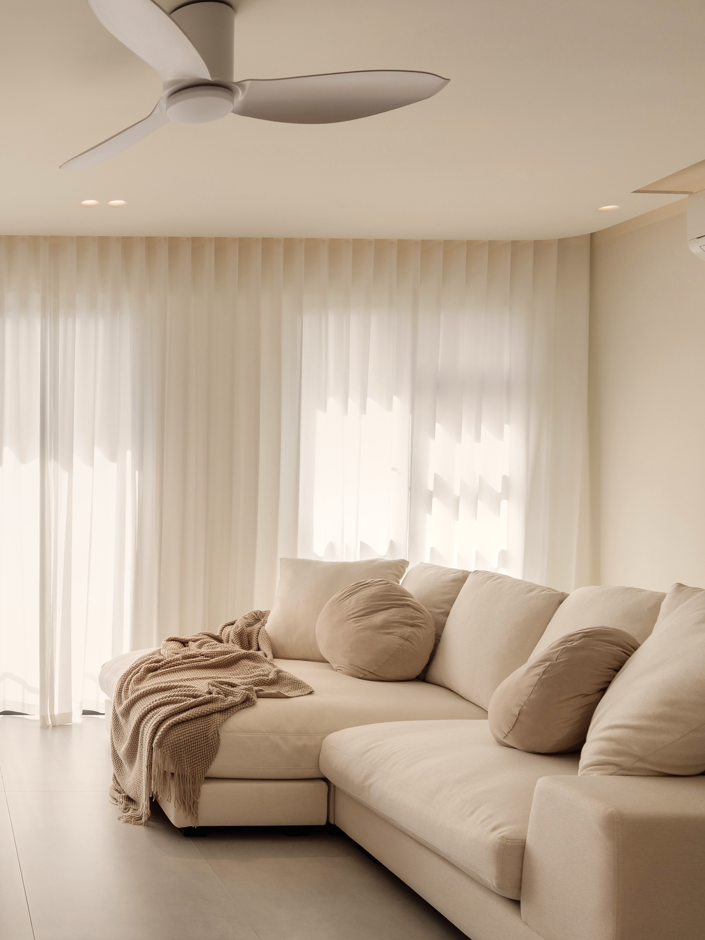 Our Creamy Home: A Home Design Diary  - Cream-colored, minimalist living room with modern ceiling fan, sheer white curtains