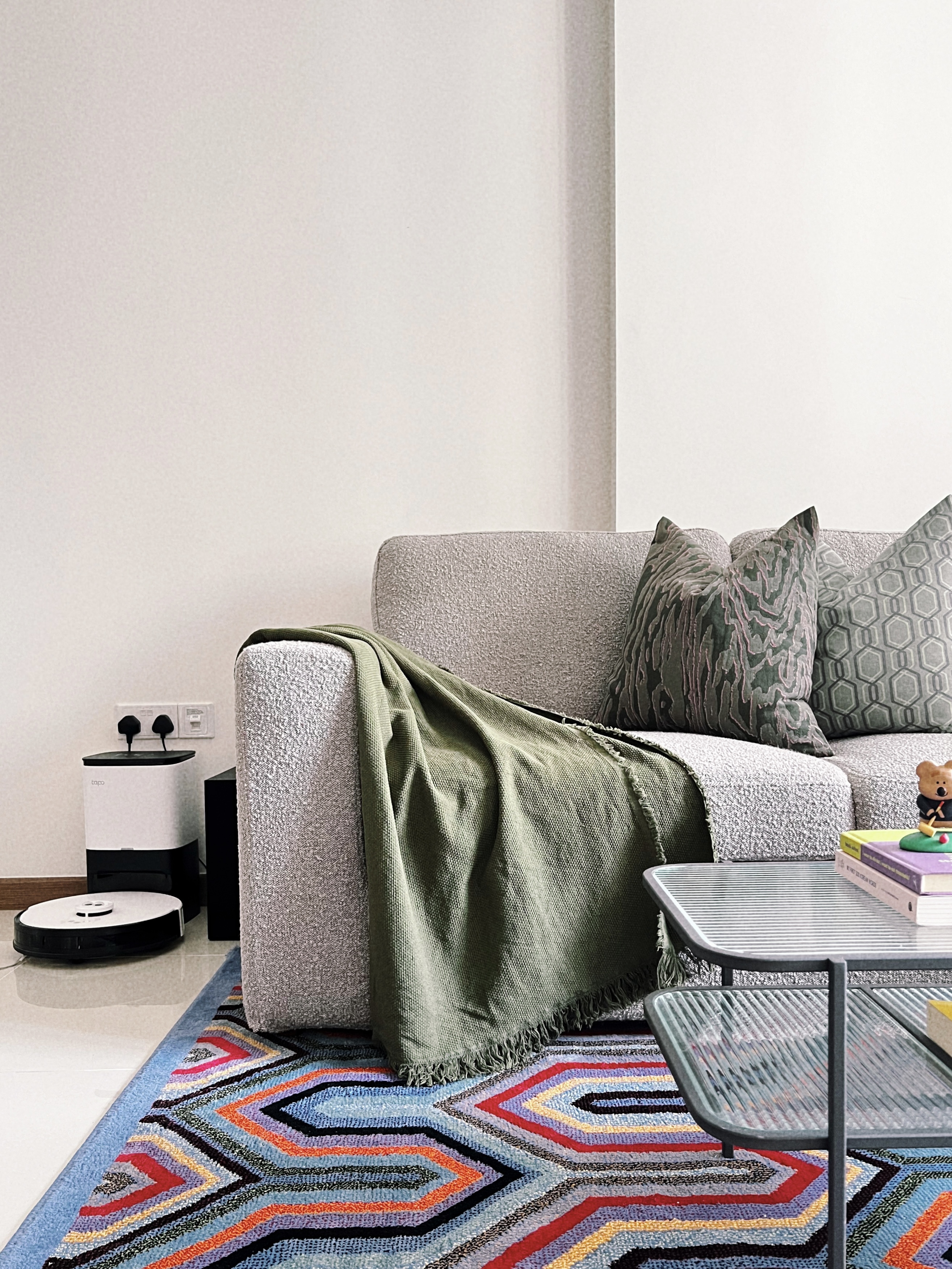 A Playground for Conversations  - gray sofa, green throw blanket, modern living room, textured upholstery, geometric rug