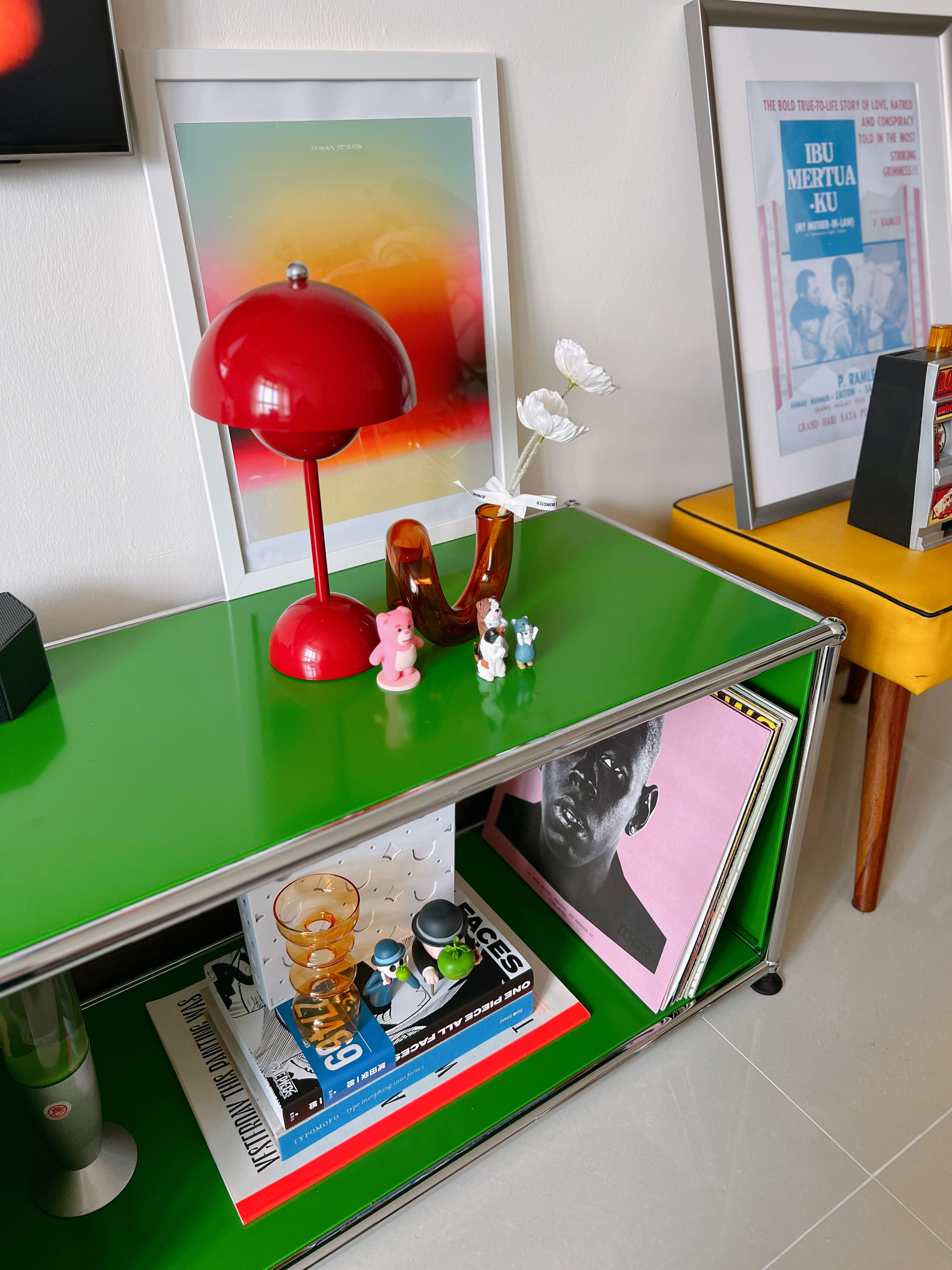 A Playground for Conversations  - Green side table, modern decor, red lamp, white flowers, small figurines, black and white