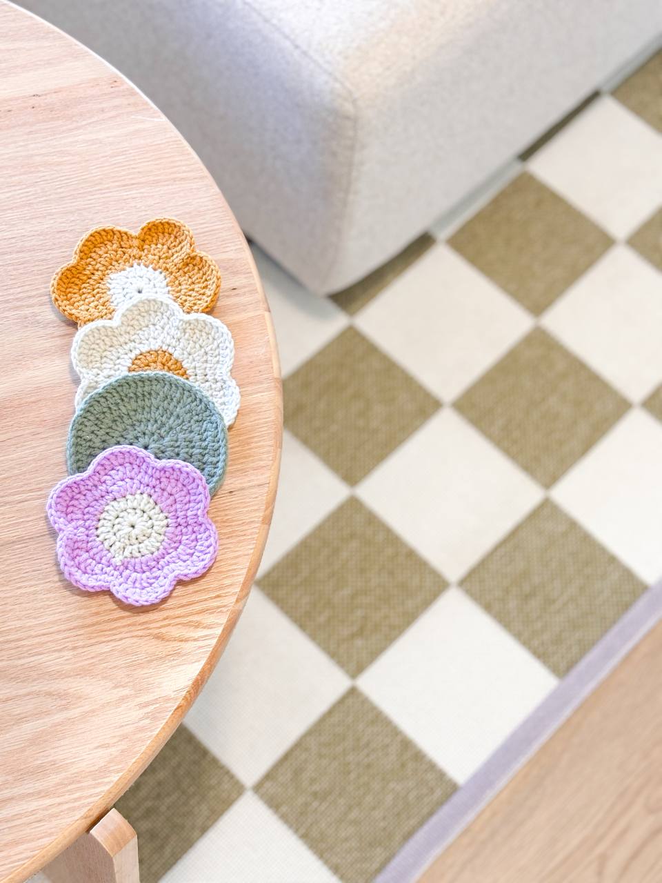 Our Living Room and It's Colours - Crocheted flower coasters in pastel colors, wooden table, checkered floor, cozy indoor