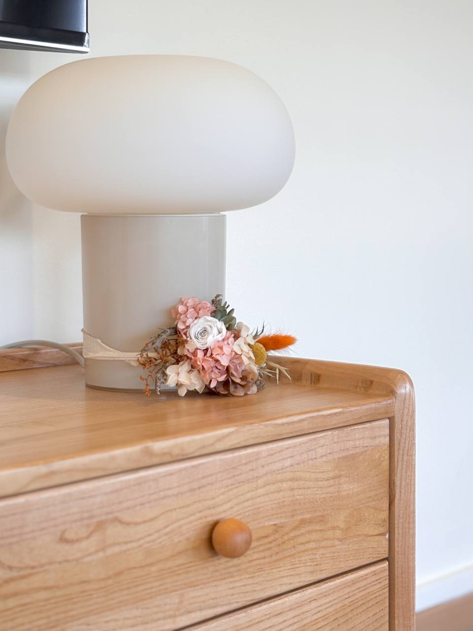 Our Living Room and It's Colours - Modern lamp with soft white shade, wooden dresser, rustic floral arrangement, pastel pink