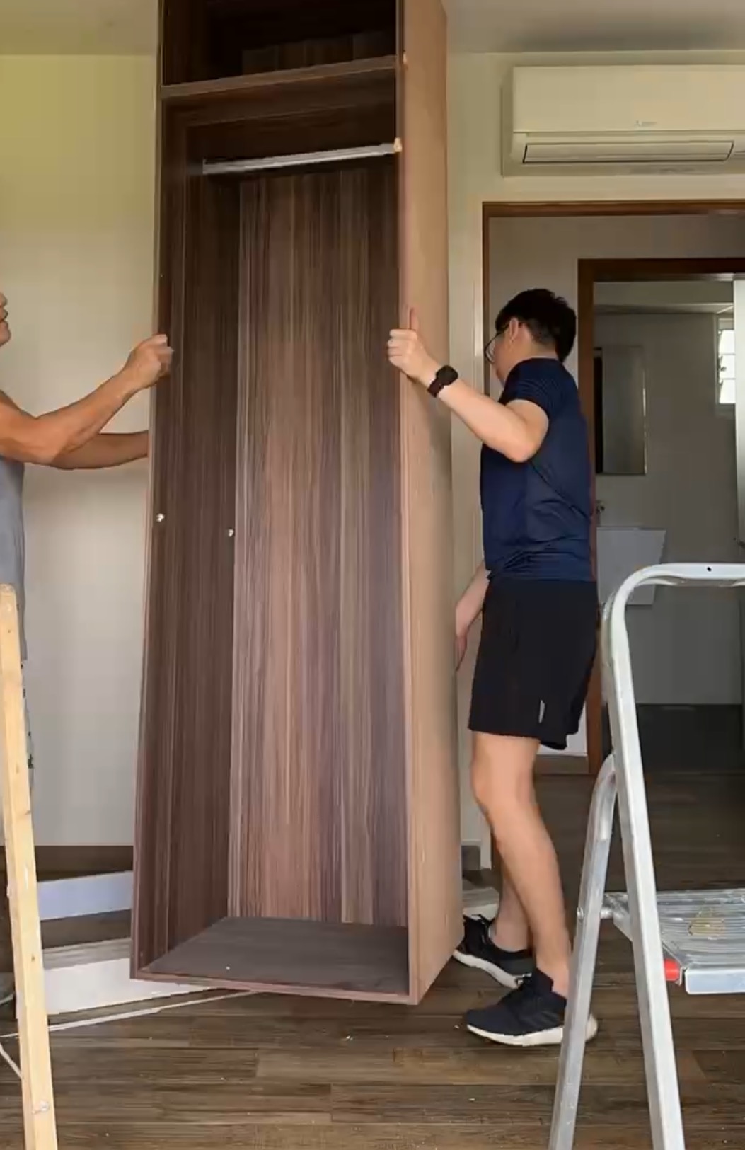 Our renovation journey as 2 "broke" newlyweds - Wooden wardrobe, man installing, ladder, dark wood finish, indoor setting