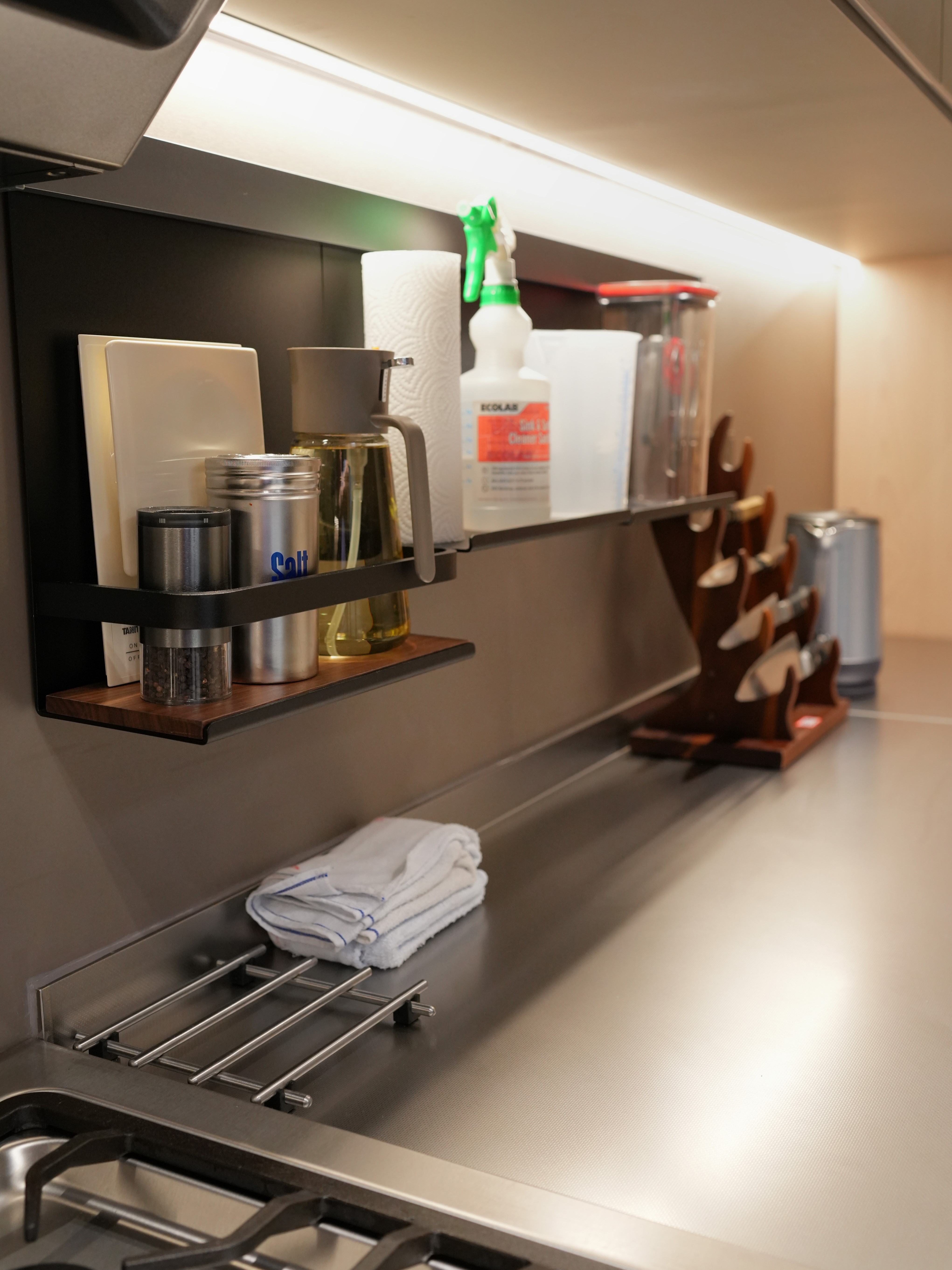 A Chef's Kitchen: Stainless Steel & Japanese Monotonal Design - Shelf with kitchen essentials, stainless steel countertop