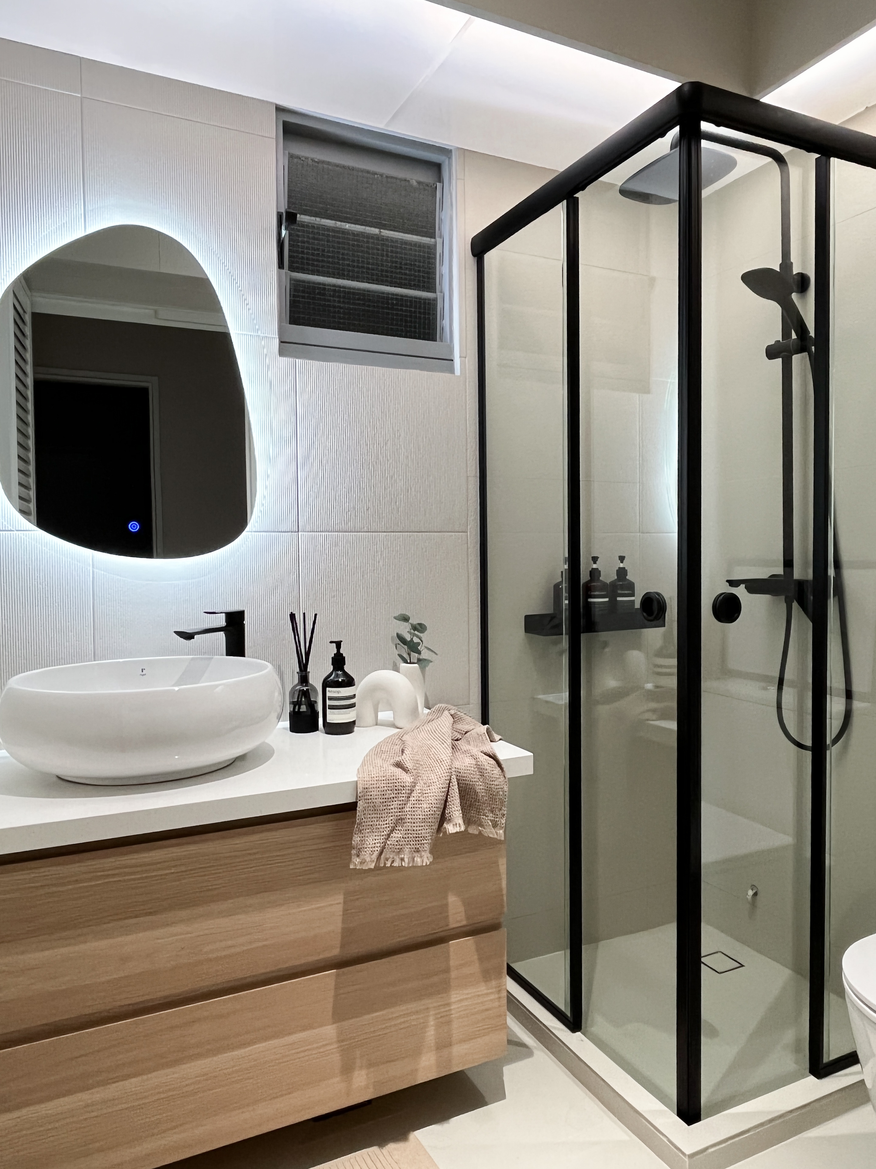 Inside Our Cosy & Airy Scandinavian 4-Room HDB - Modern bathroom with sleek design, minimalist decor, large oval mirror