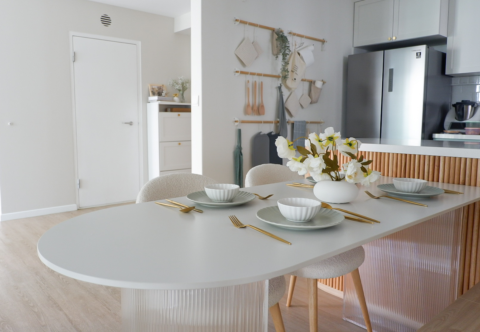 Inside Our Cosy & Airy Scandinavian 4-Room HDB - Modern minimalist dining room with sleek white table, elegant gold cutlery
