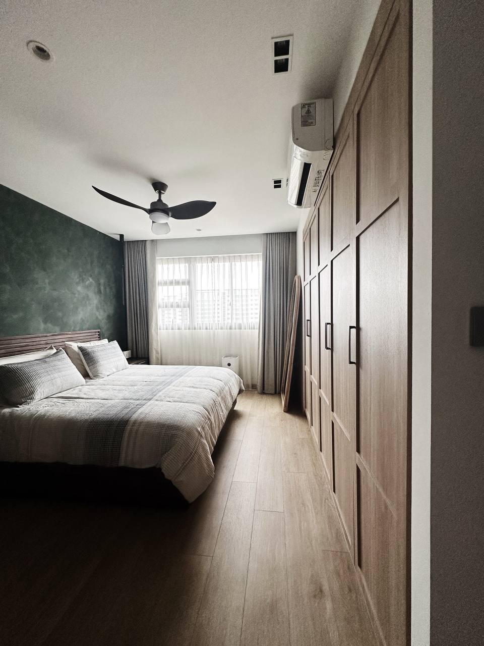 3 ID Green Flags 💚🍏 - Modern bedroom with wooden flooring, large bed with gray and white bedding, ceiling fan with black