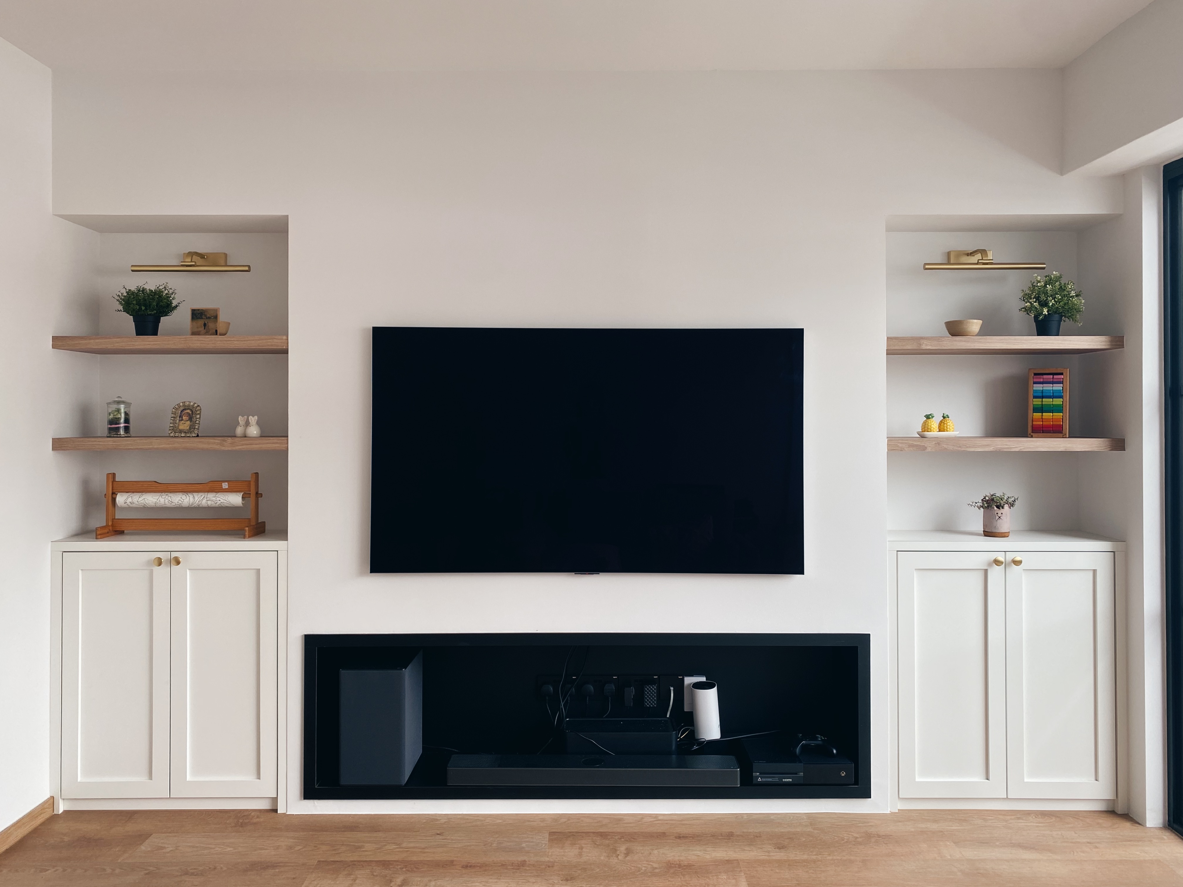 Our Family Friendly Haven: A Modern Farmhouse Living Room - Wooden shelves, minimalist decor, white cabinets, black TV