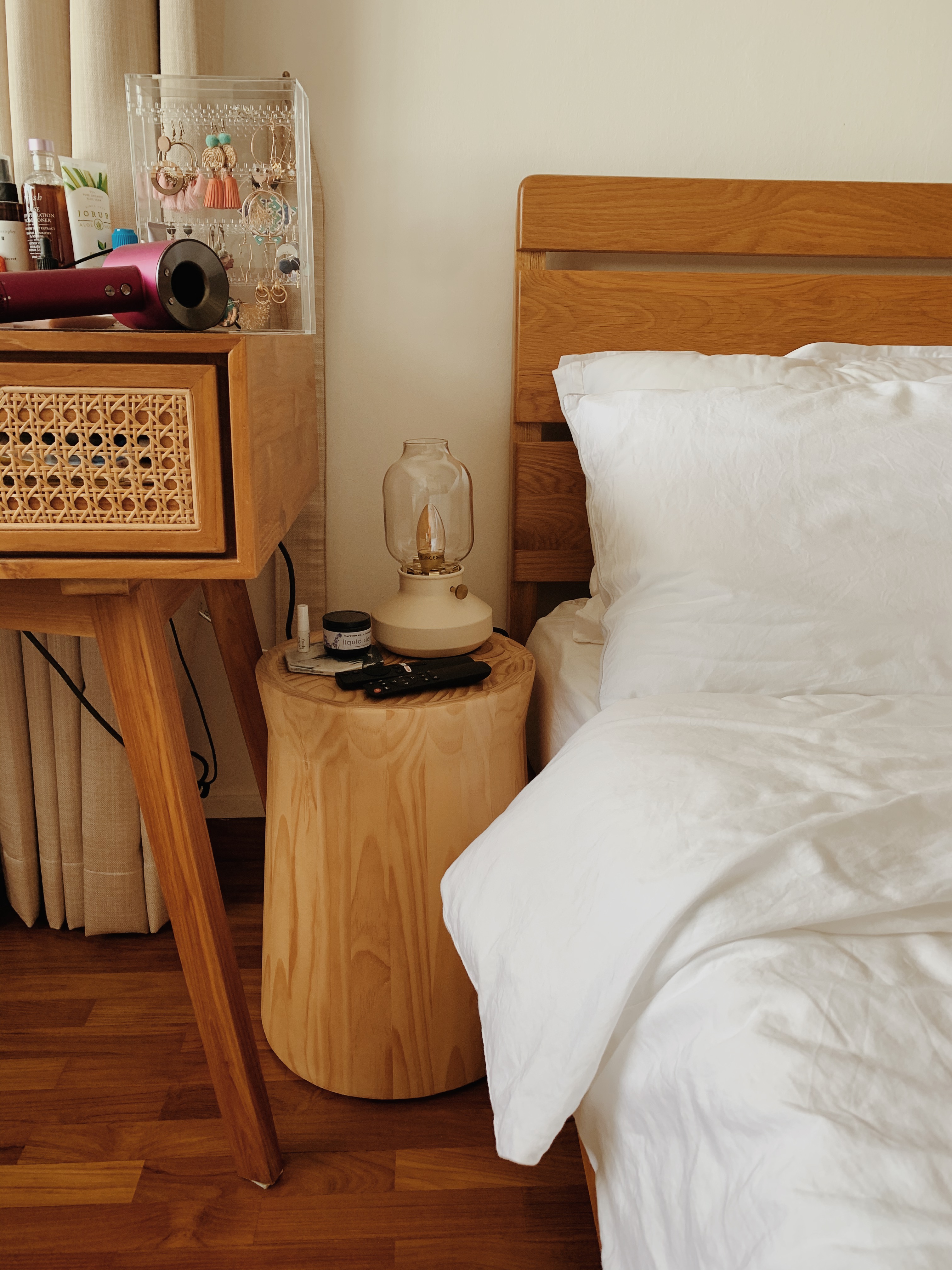Cozy Farmhouse Bedroom with Projector and Faux Fireplace - Wooden nightstand, white bed, wooden floor, bedside table, lamp