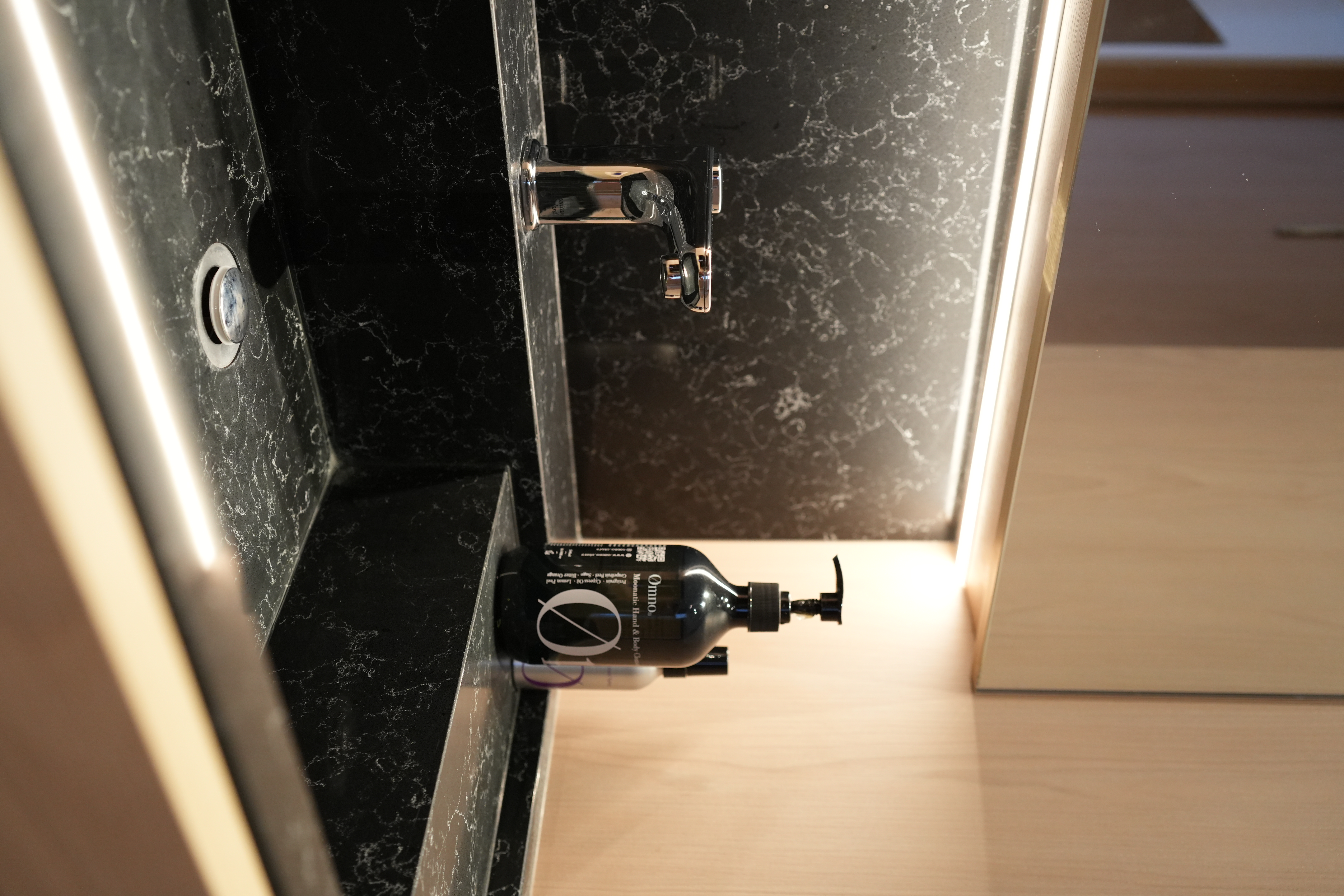 Our Bathroom: Dual Showers, Onsen Style Sit-Downs & A Powder Room - Black marble countertop, sleek faucet, modern bathroom