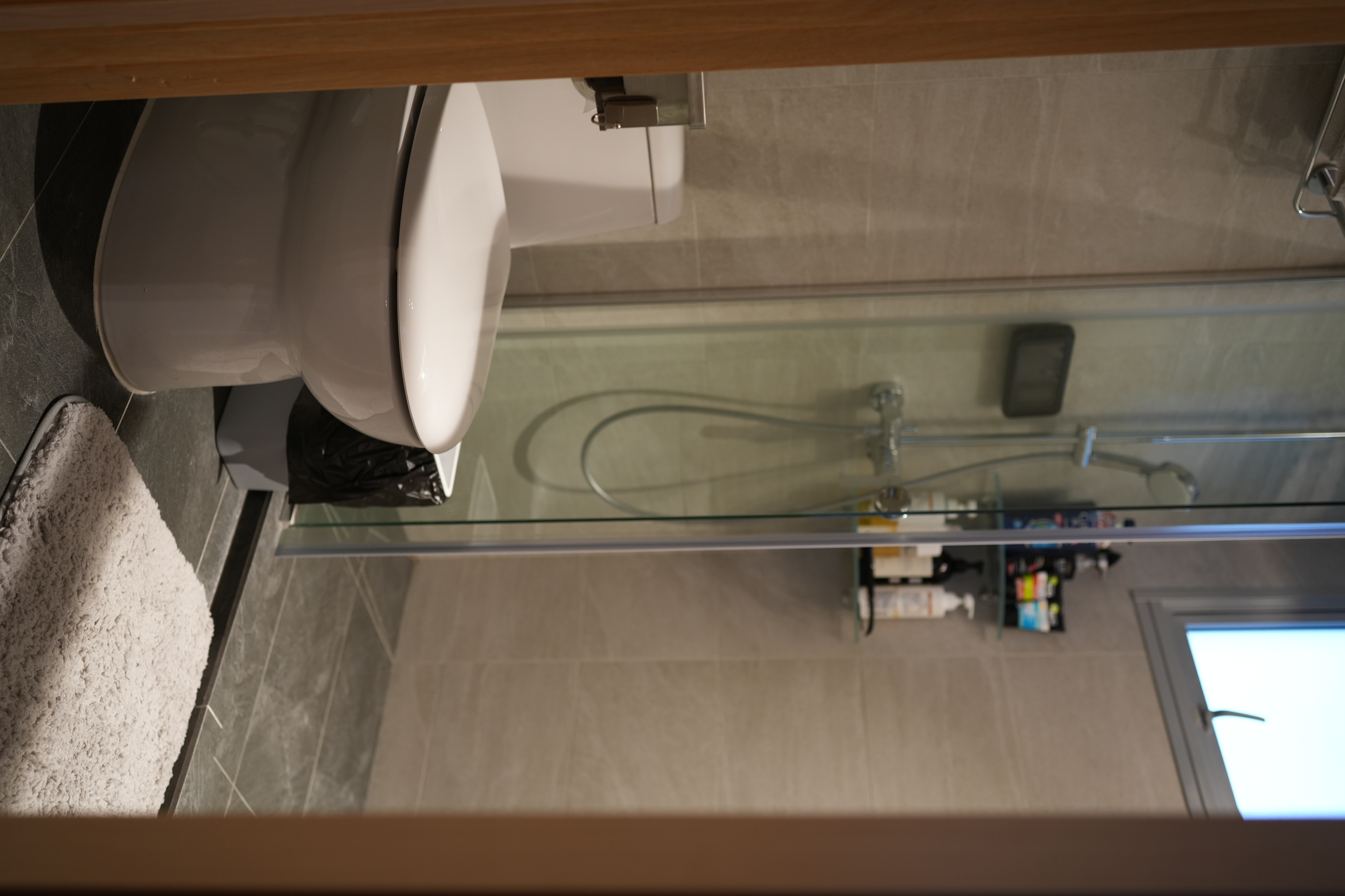 Our Bathroom: Dual Showers, Onsen Style Sit-Downs & A Powder Room - White toilet, bathroom floor, gray tiles, wooden shelf