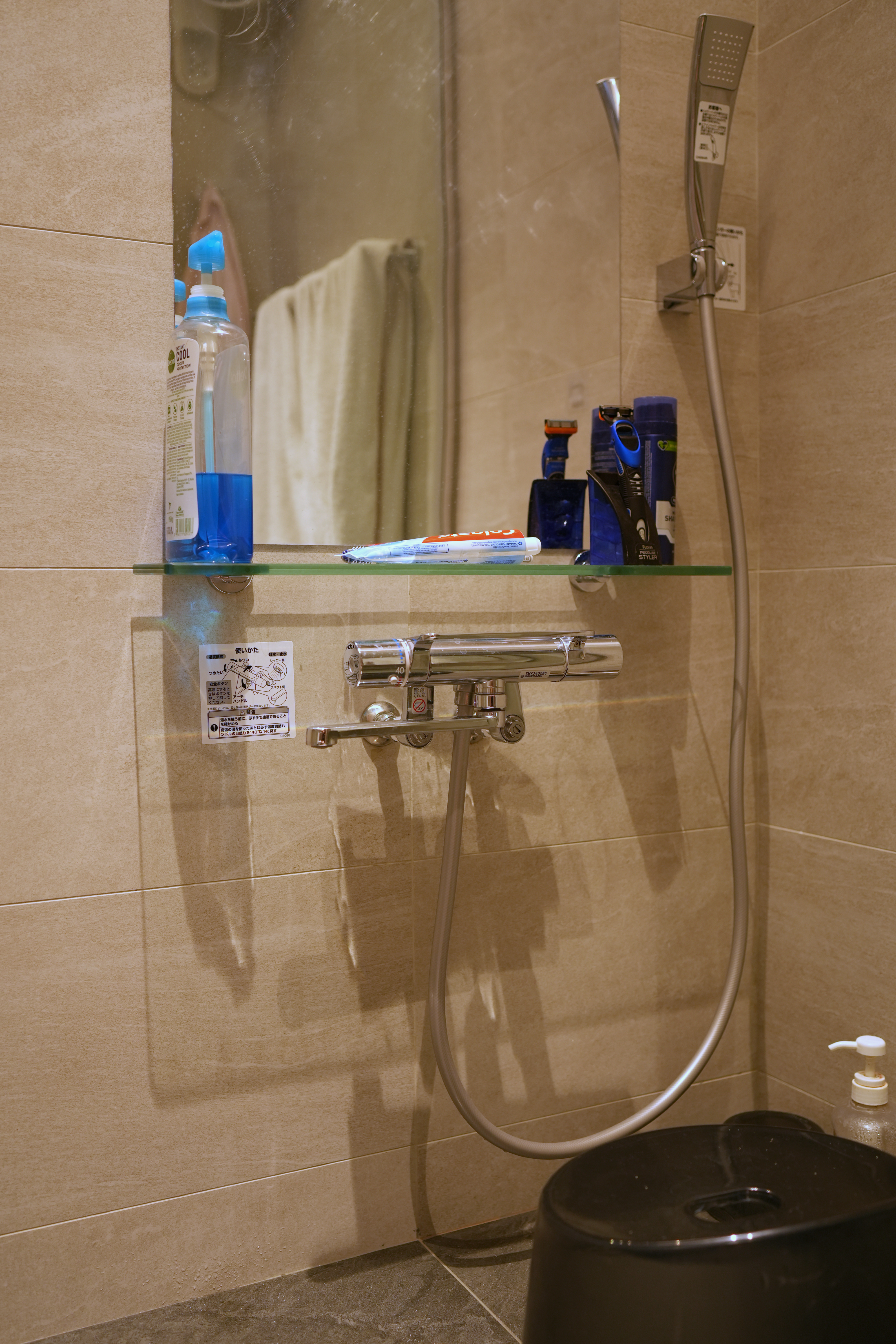 Our Bathroom: Dual Showers, Onsen Style Sit-Downs & A Powder Room - Shower area with toiletries, beige tiled walls, glass