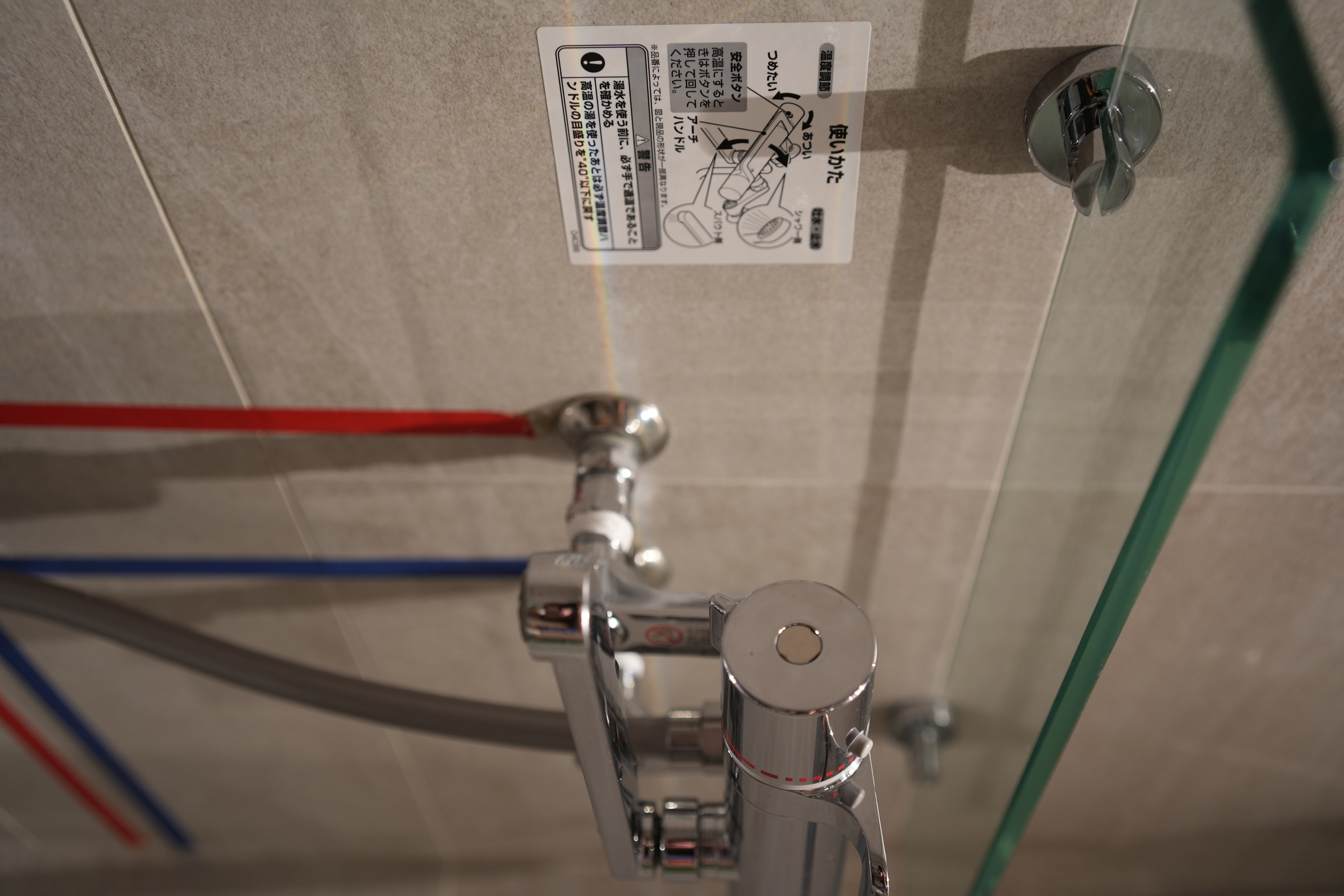 Our Bathroom: Dual Showers, Onsen Style Sit-Downs & A Powder Room - shower head, metallic faucet, red and blue hoses, tiled