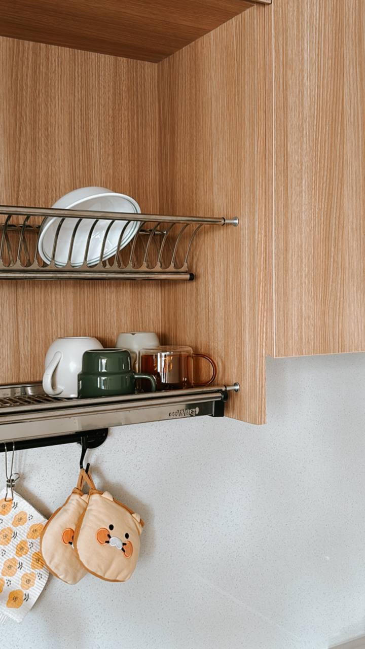 Our Favourite Part - The Kitchen! - Wooden kitchen cabinet, metal dish rack, white plates, green mug, brown mug, stainless