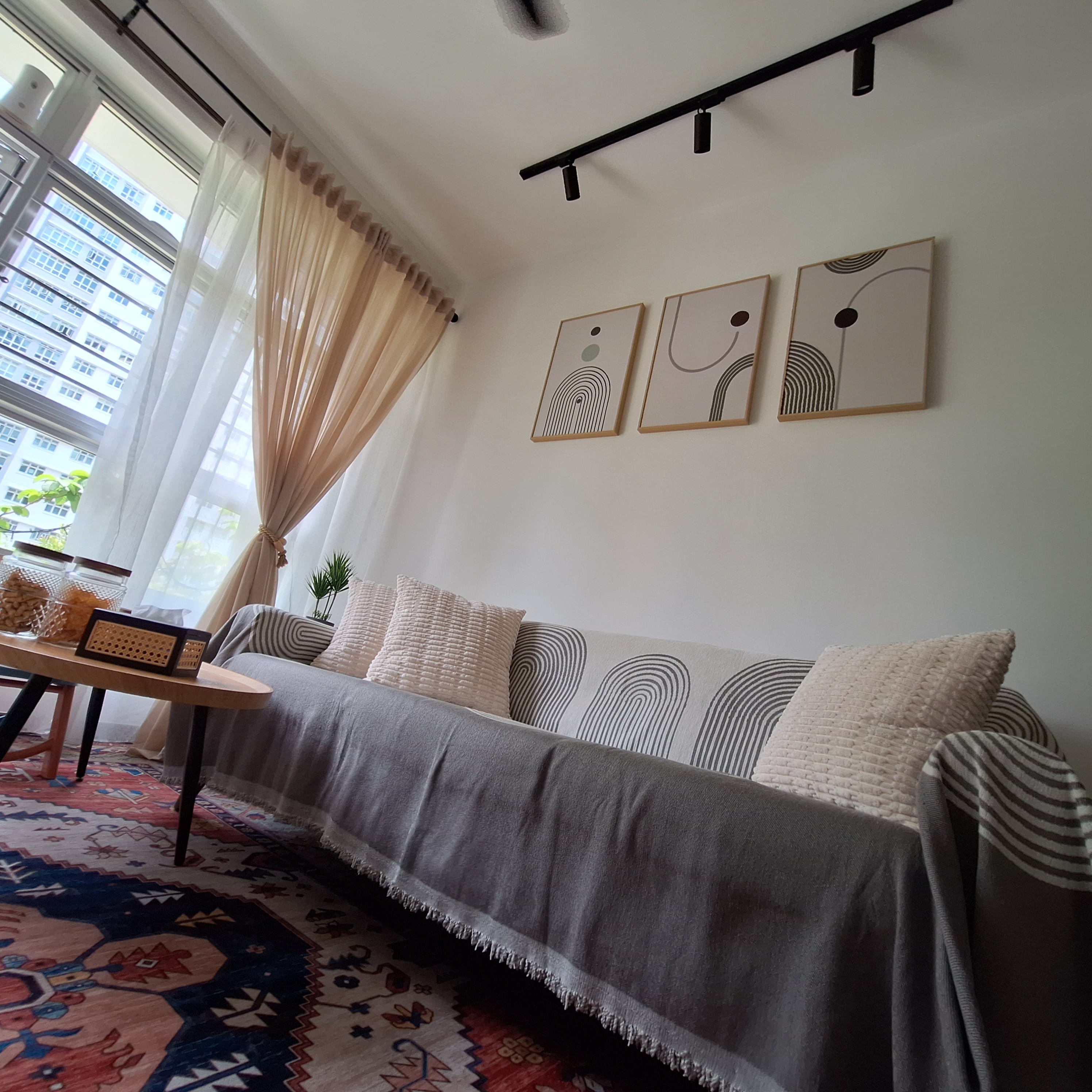 Raya vibes - Modern living room with comfortable sofa, beige curtains, abstract art on wall, natural light from large