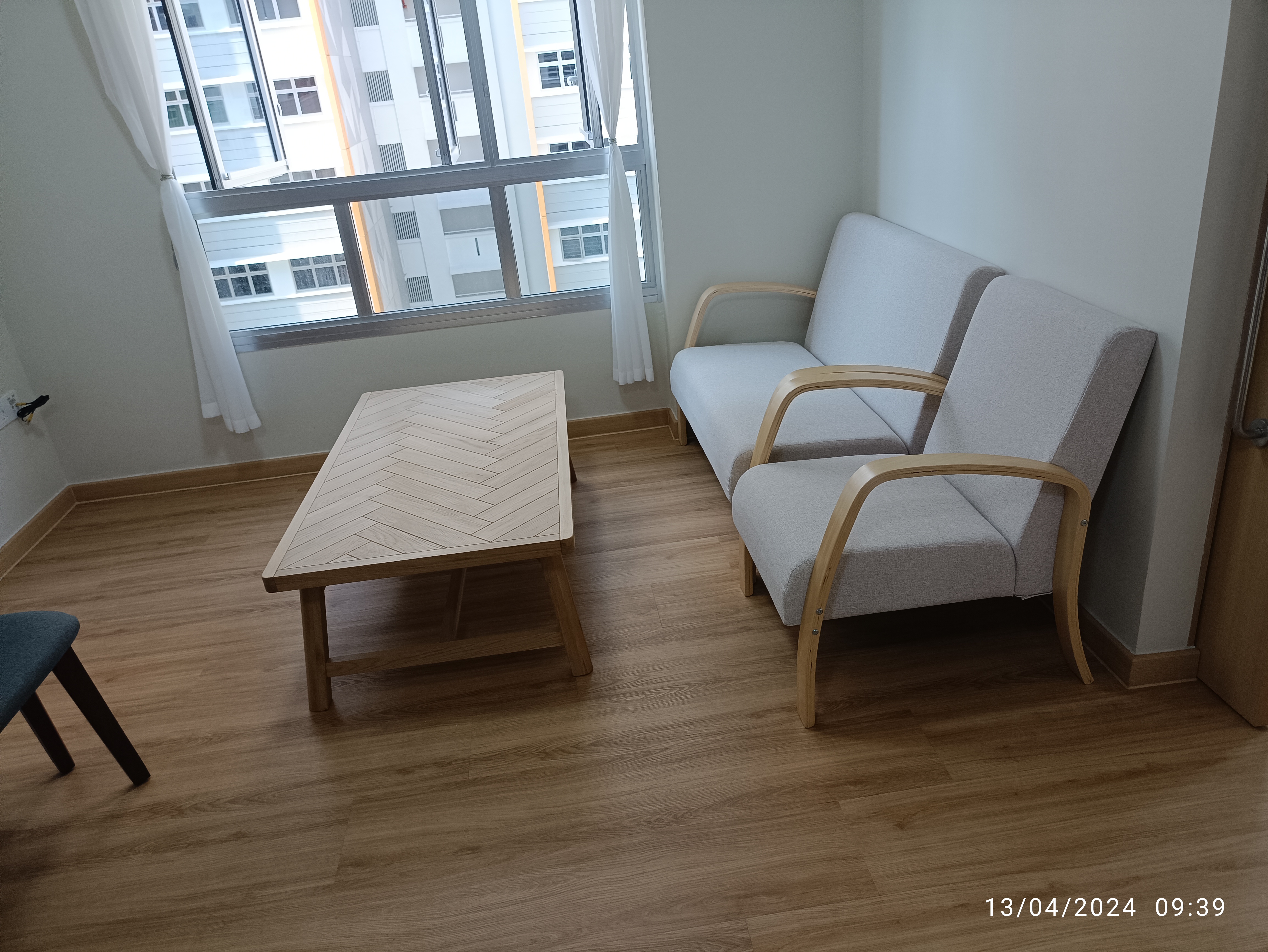 Minimalist Botak House - Modern living room, minimalist design, cozy seating, light gray sofa, wooden coffee table, natural