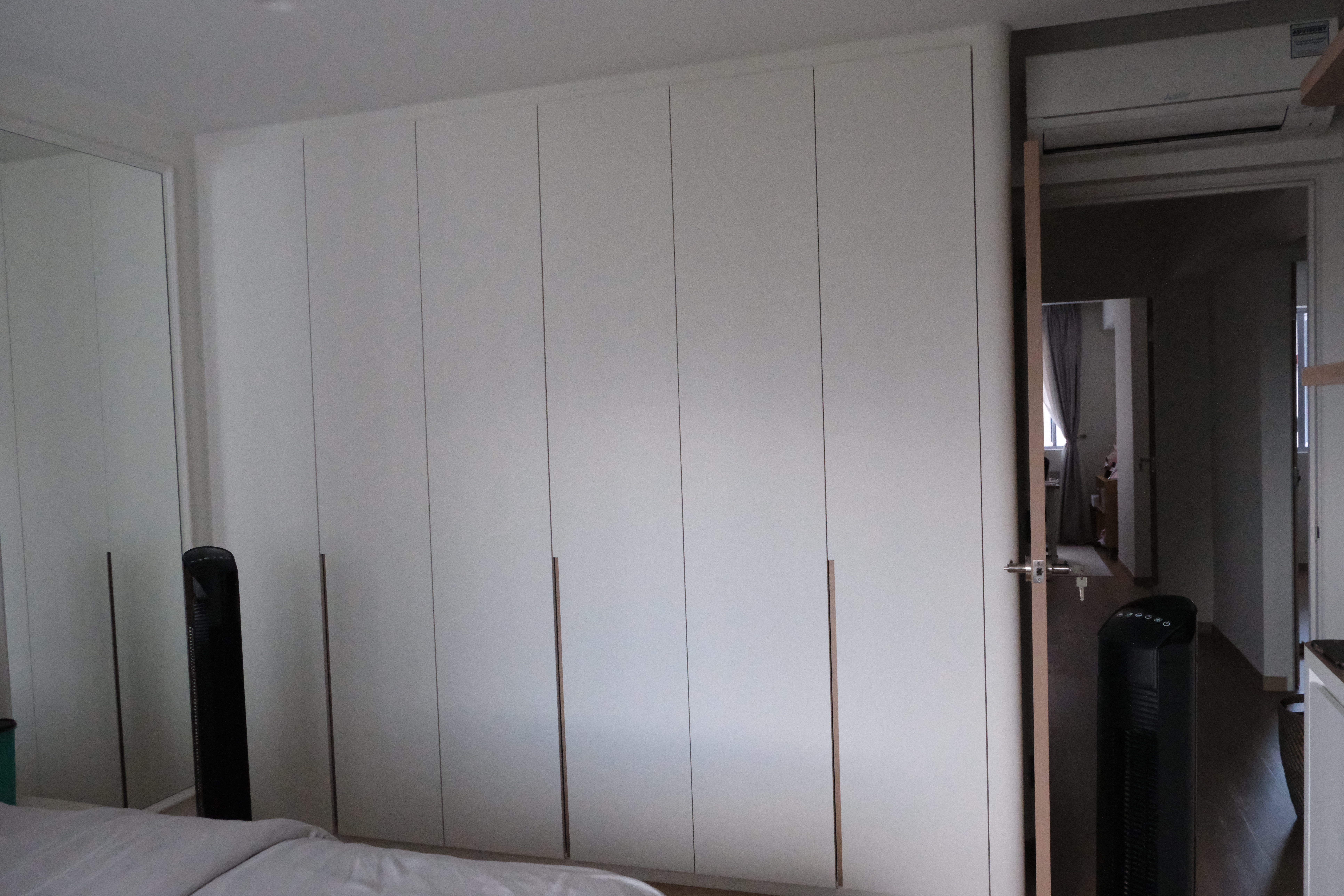 Discover Tranquility: A Scandinavian-Inspired Master Bedroom - White wardrobe with vertical handles, black standing fan, open