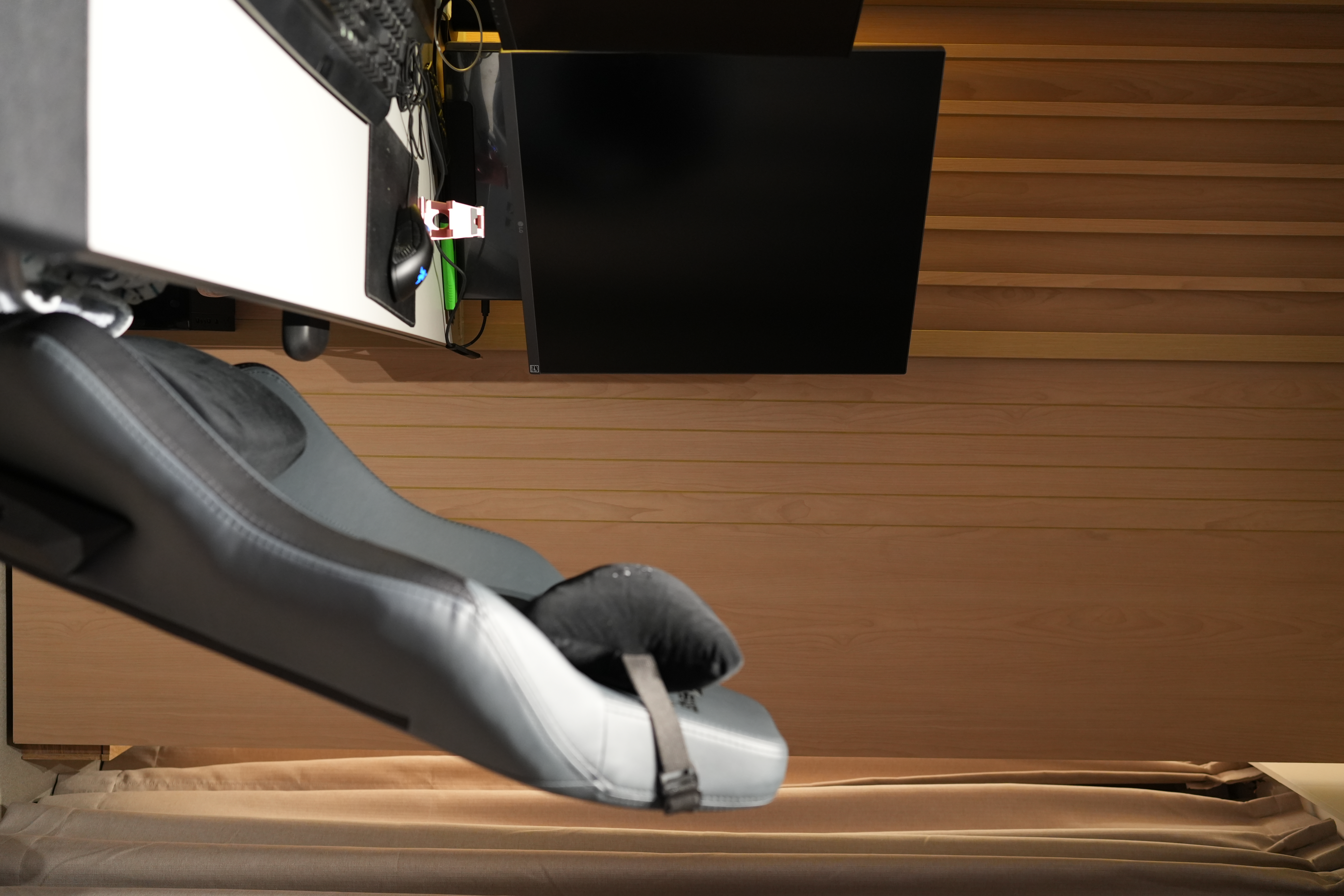 An Essential Study in 4m² - Black gaming chair, wooden wall paneling, black desk, black computer monitor, black keyboard