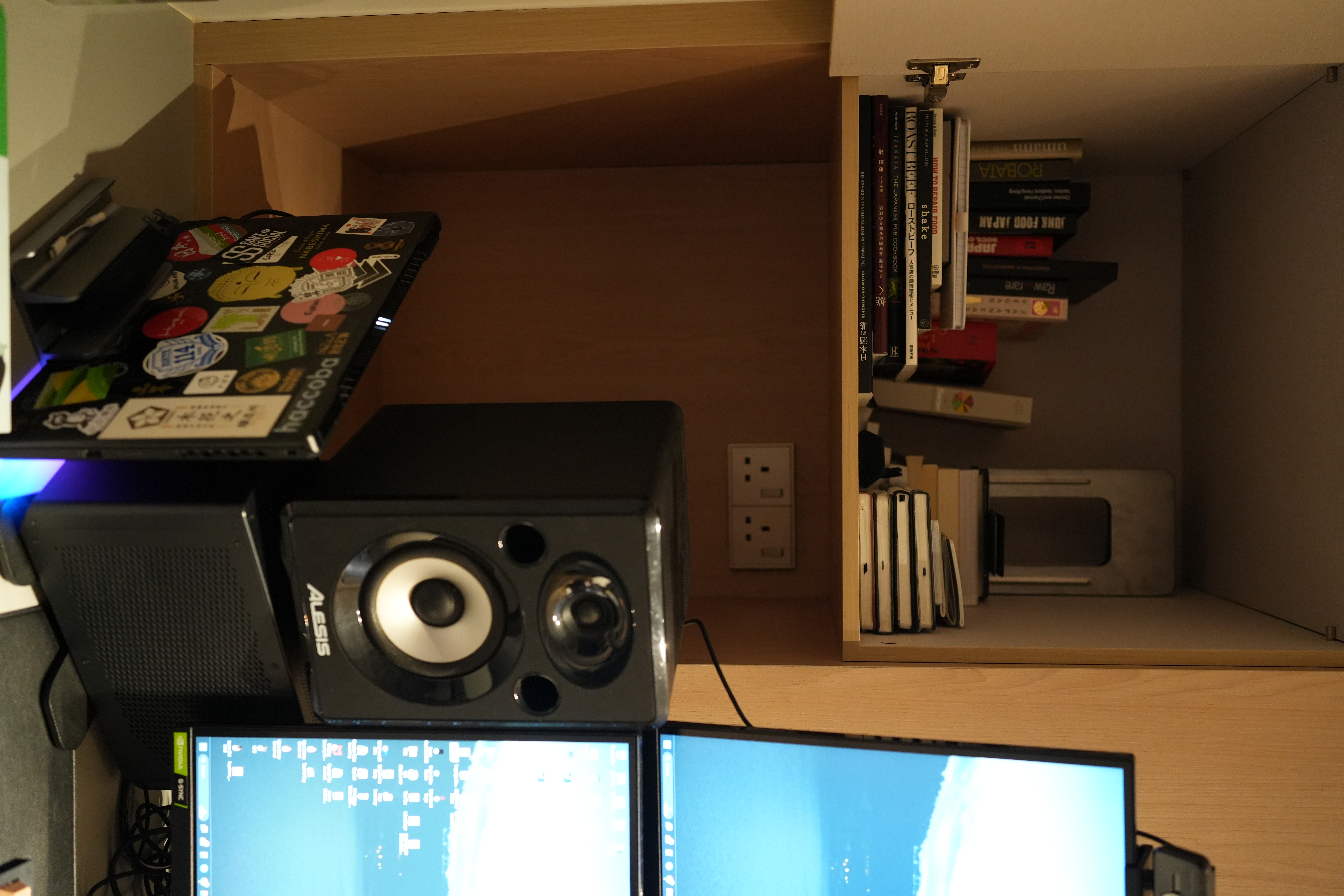 An Essential Study in 4m² - Computer desk, dual monitors, speaker, computer setup, cluttered workspace, books, open book