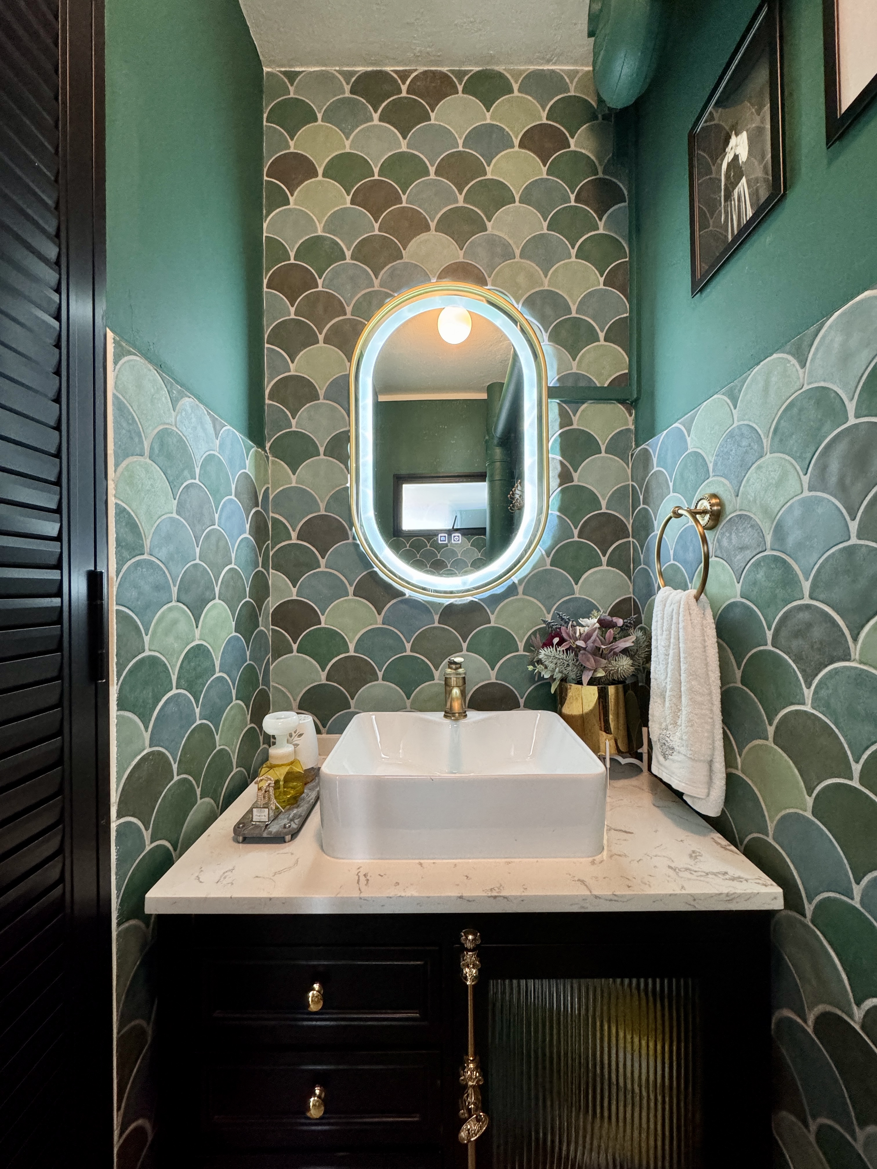 The Mermaid's Castle (Bathroom 1/3) - Marble vanity, oval mirror, green and blue tiles, modern design, white sink, gold