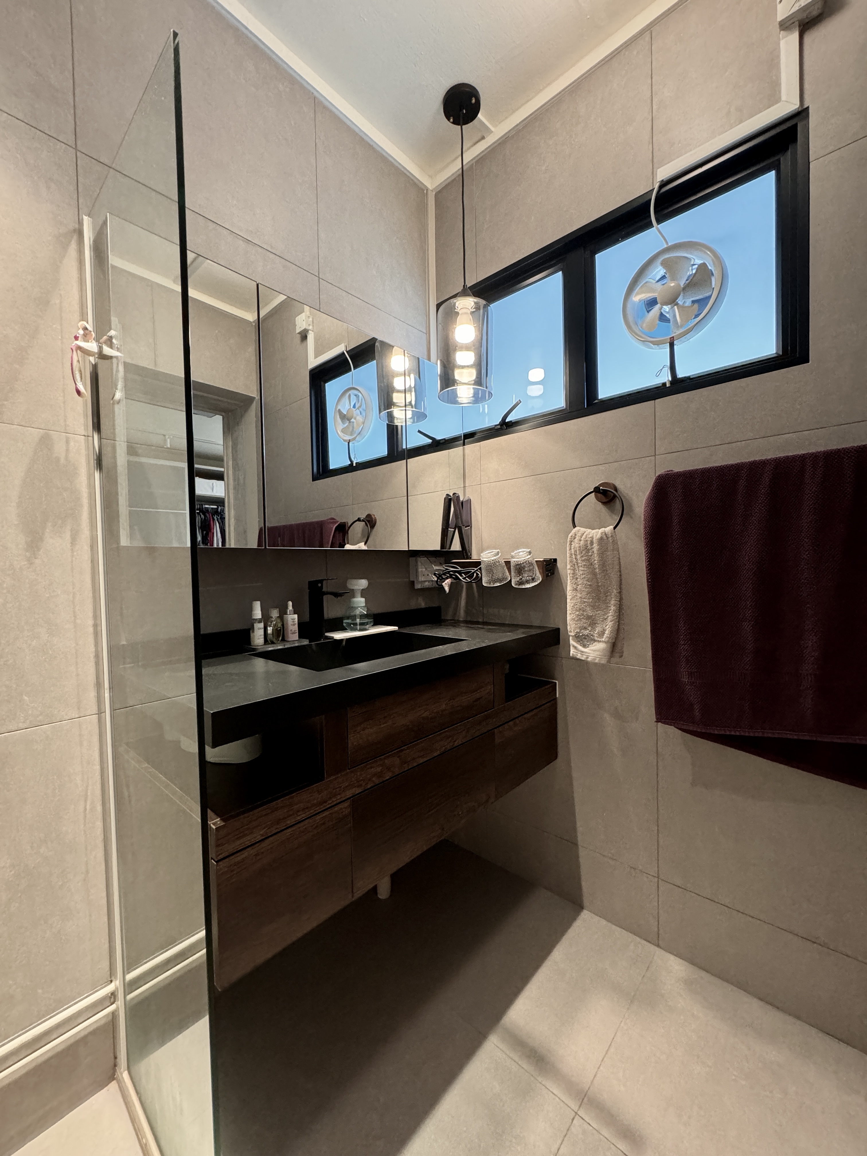 The Spa Within a Cave (Bathroom 2/3) - Modern bathroom with sleek design, large mirror, glass shower enclosure, black