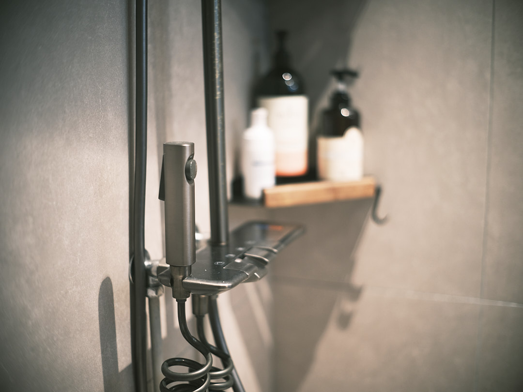 The Spa Within a Cave (Bathroom 2/3) - shower head, shower caddy, metallic showerhead, black shower caddy, modern shower