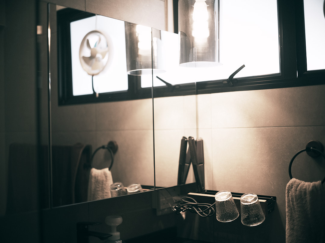 The Spa Within a Cave (Bathroom 2/3) - Bathroom vanity, mirror reflection, soft lighting, modern design, glass panel, towel