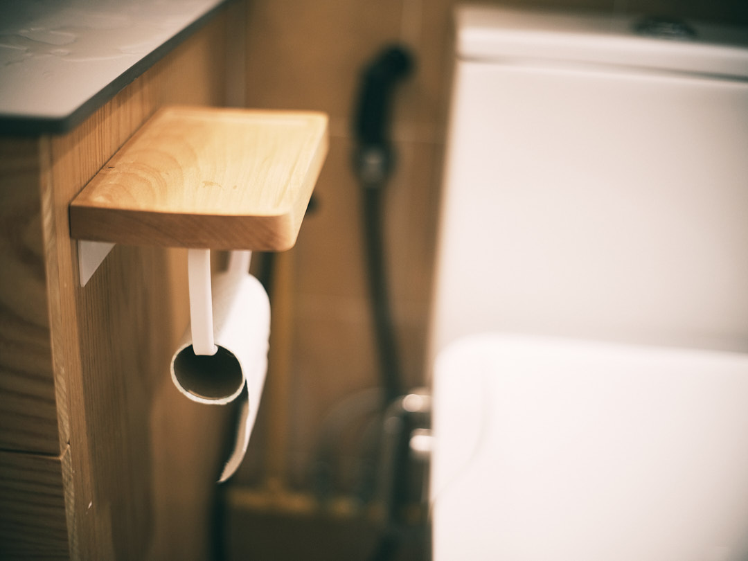 The Cheerful Swimming Pool (Bathroom 3/3) - Wooden bathroom shelf, toilet paper holder, white toilet, wooden surface, wooden
