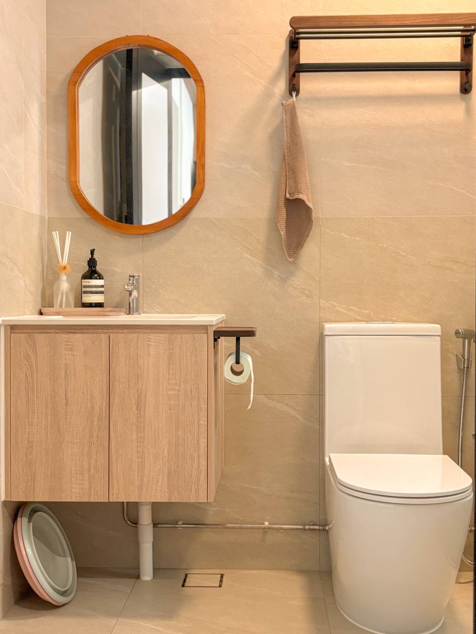 Our Biggest Reno Regrets and Reno Wins - Both in the Bathrooms - Wooden vanity, round mirror, beige tiles, wooden shelf