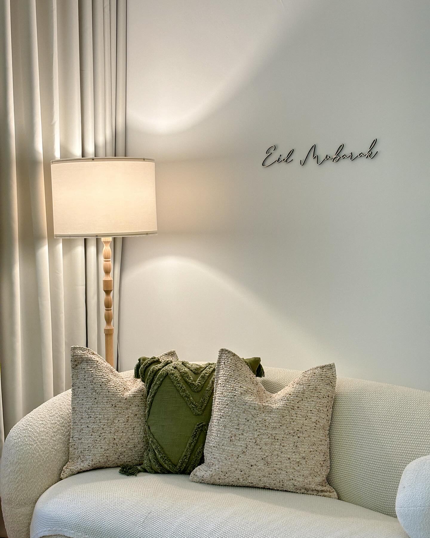 Our Simple & Cosy Living Room - Cream-colored sofa, green throw blanket, textured pillows, elegant wooden lamp, soft