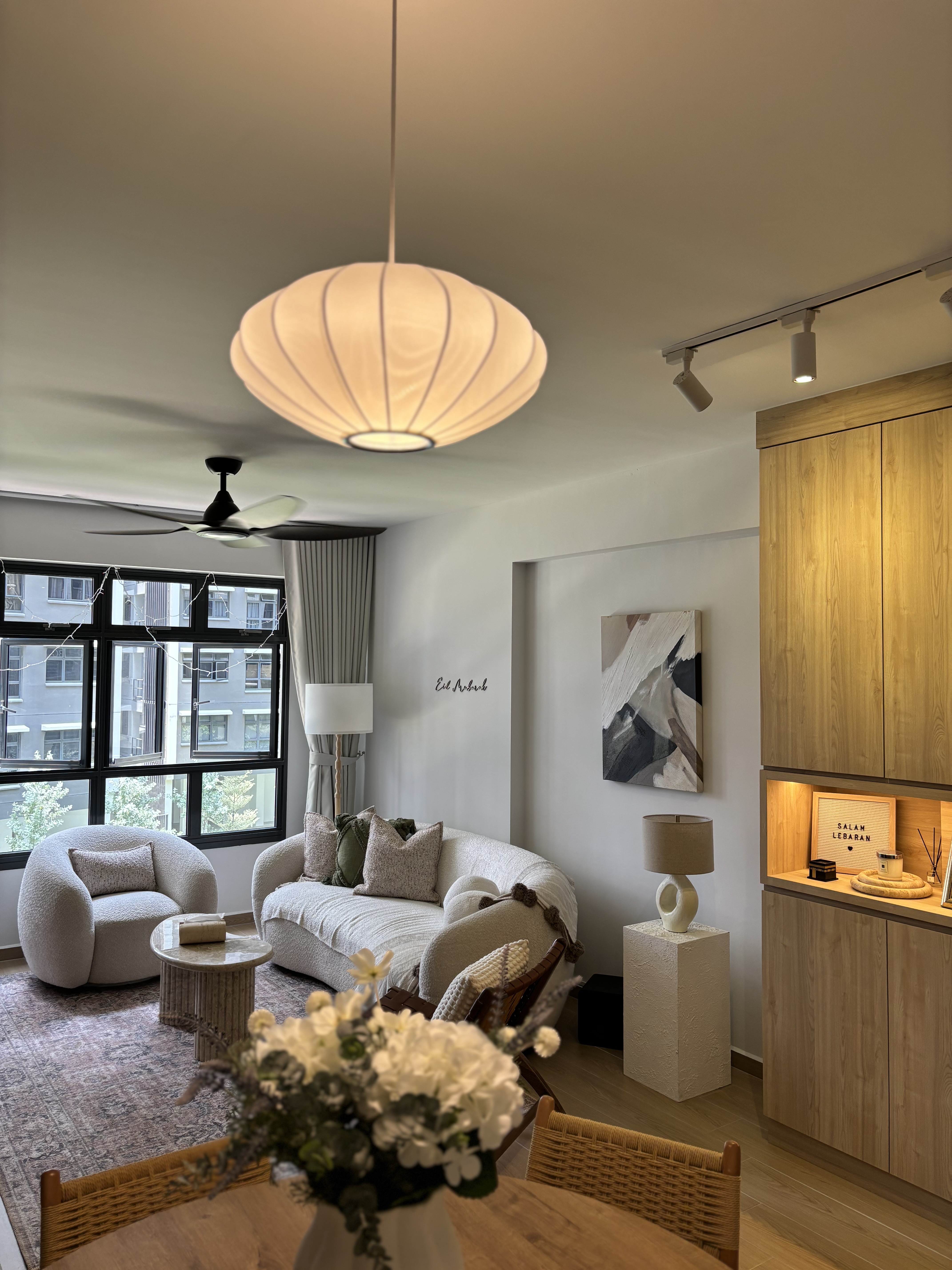 Our Simple & Cosy Living Room - Modern living room with large windows, beige sofa, white armchair, floor lamp, decorative