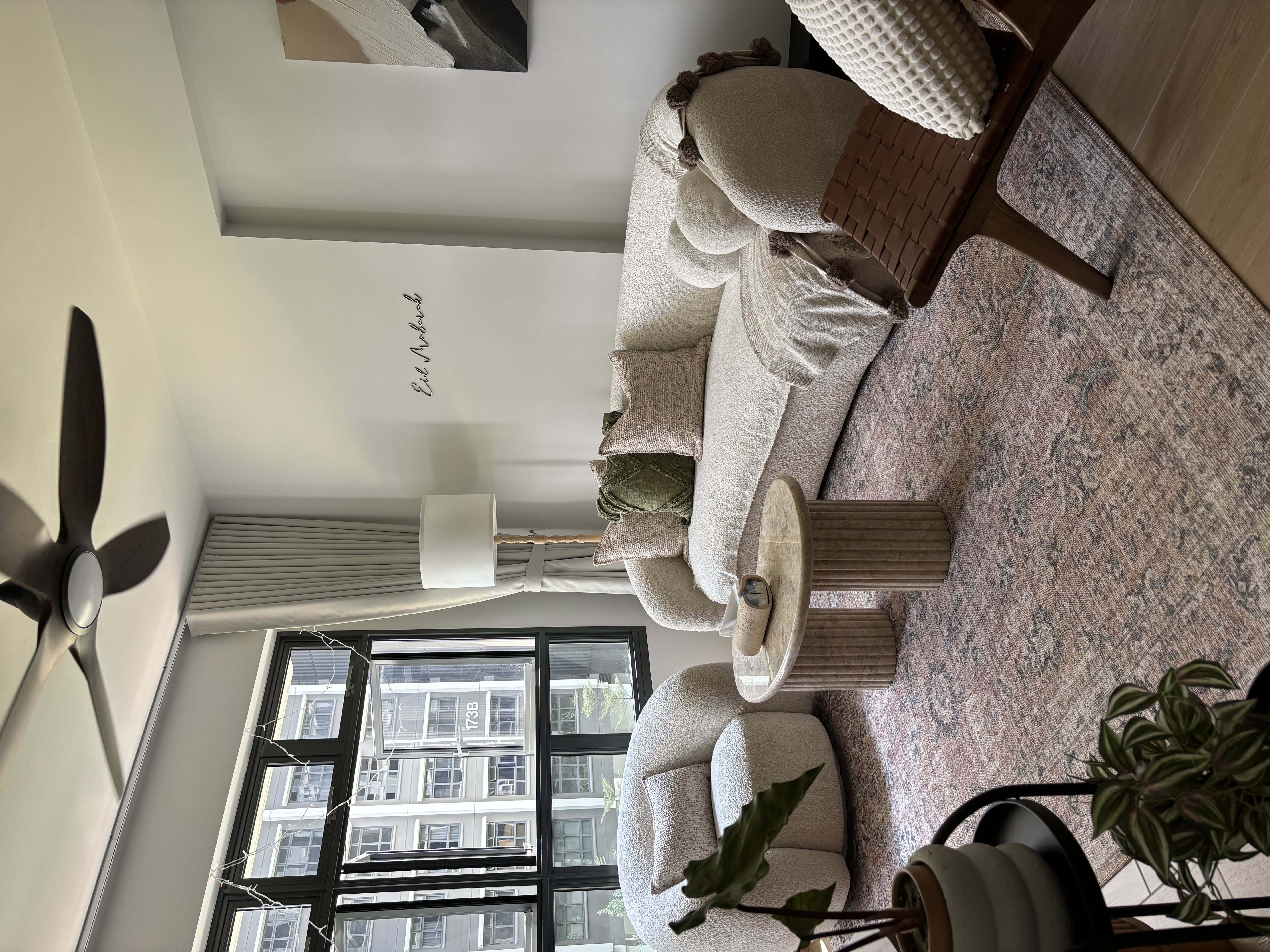 Our Simple & Cosy Living Room - Modern living room with beige sofa, textured rug, wooden coffee table, floor fan, large