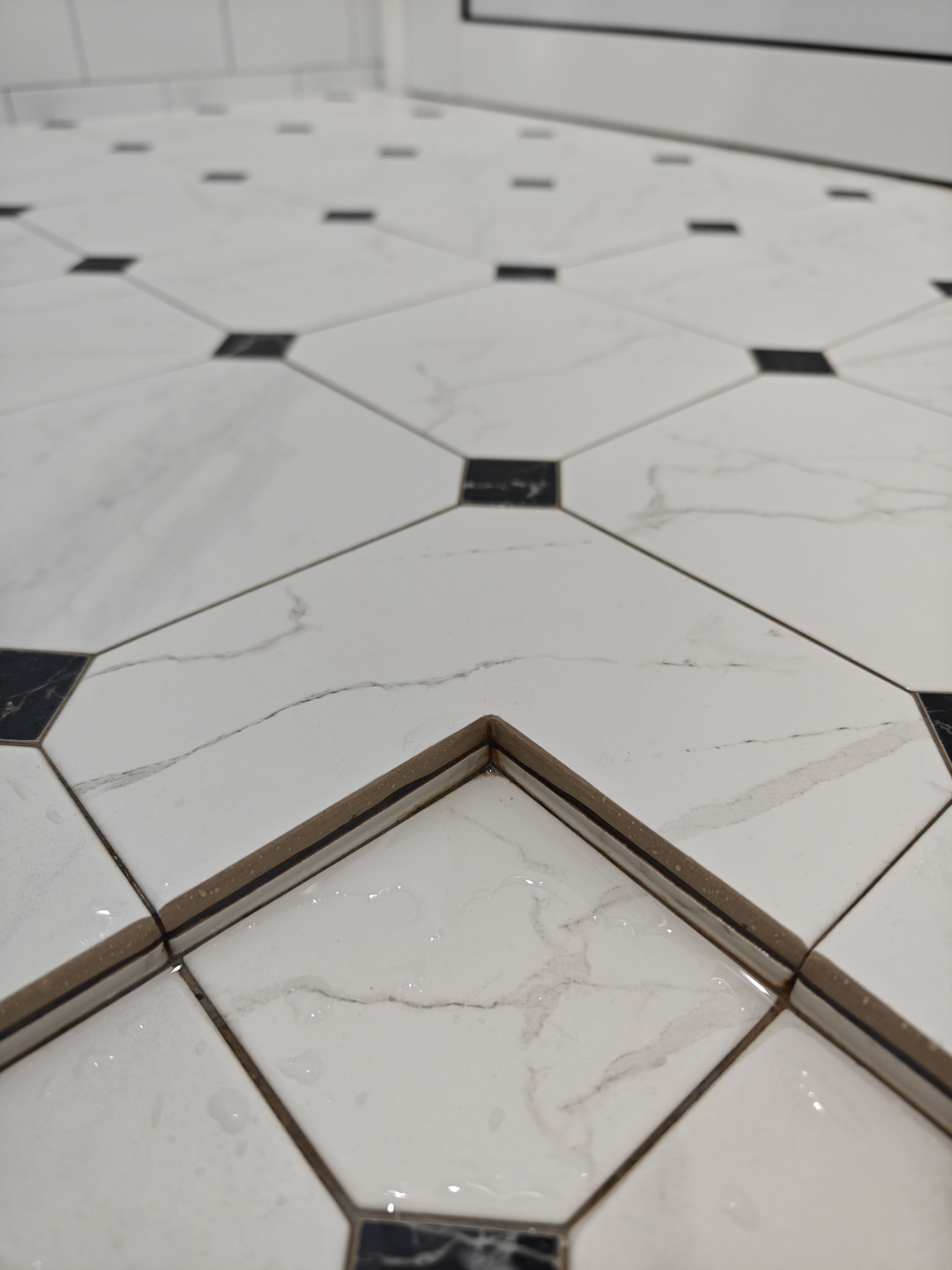 "Oh You Have 3 Bathrooms?!" - White tiled floor with black accents, glossy tiles, geometric pattern, water droplets