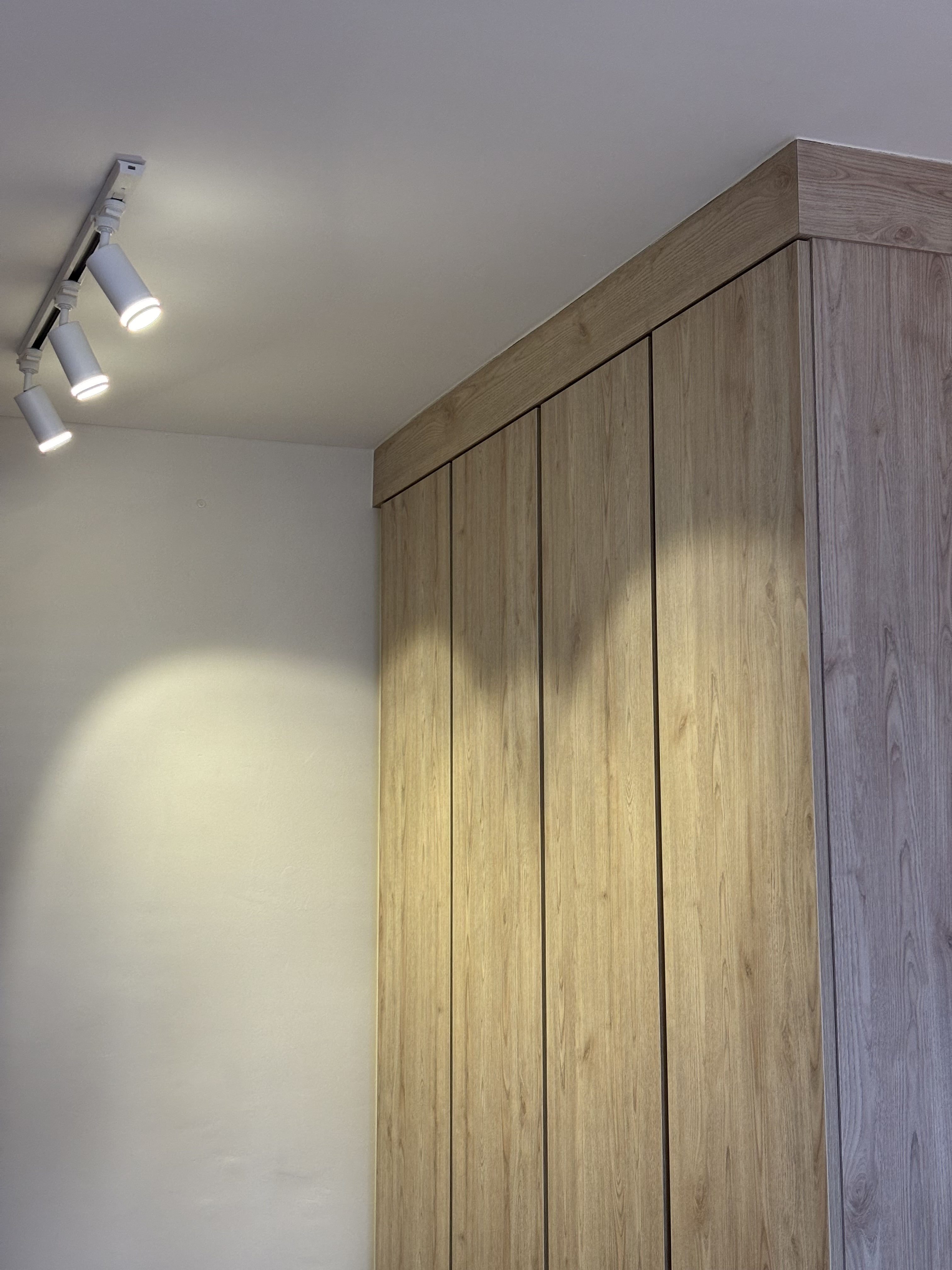 A peek inside our Master Bedroom - Wooden wardrobe, modern design, natural wood finish, vertical slats, ceiling lights