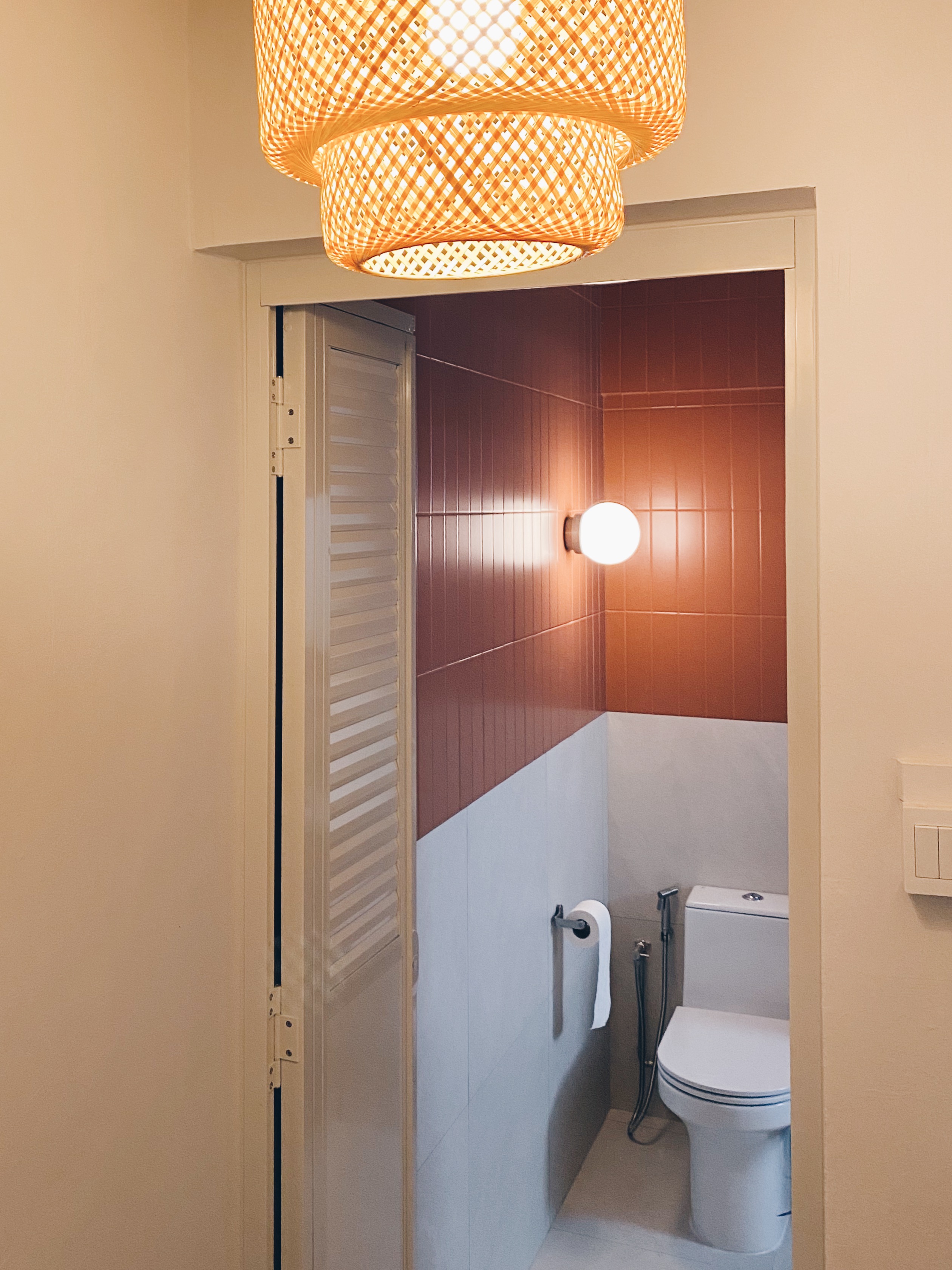 Our Bathrooms and their Personalities - Modern bathroom with warm lighting, beige walls, red and white tiled walls, white