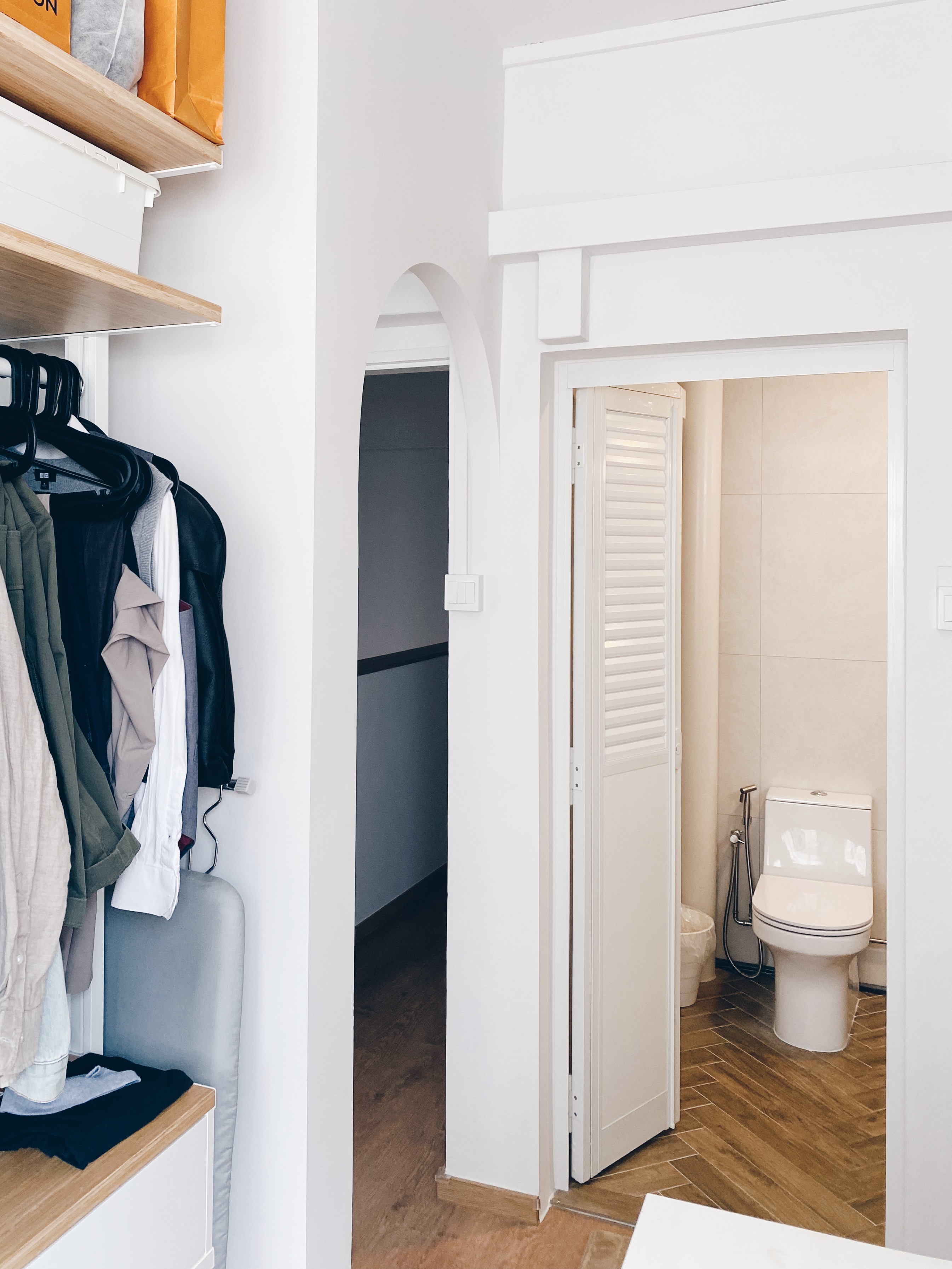 Our Bathrooms and their Personalities - Shelving unit with clothes, white interior, open doorway, bathroom, toilet, wooden