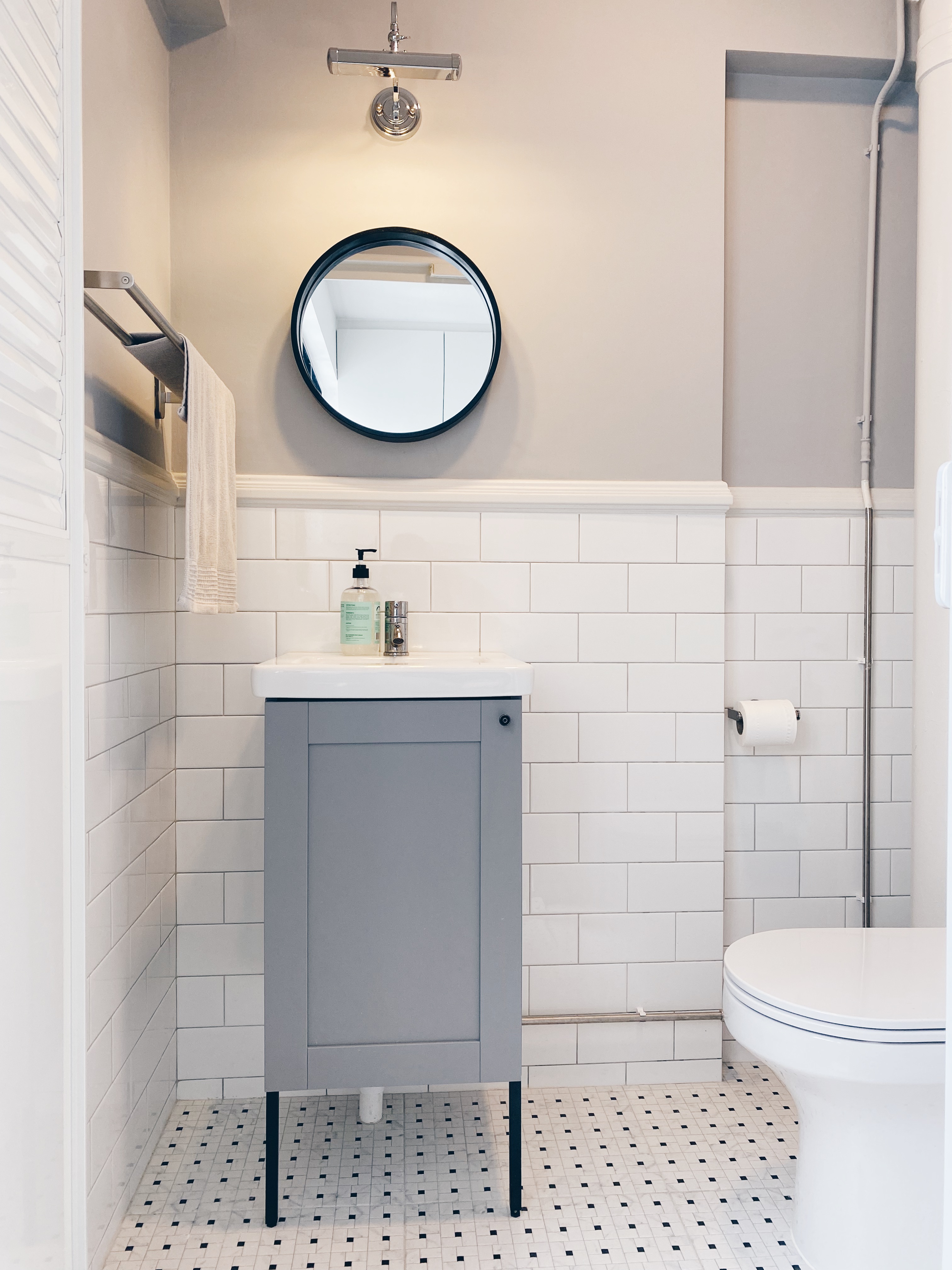 Our Bathrooms and their Personalities - modern bathroom, minimalist design, white tiled walls, gray vanity, round mirror