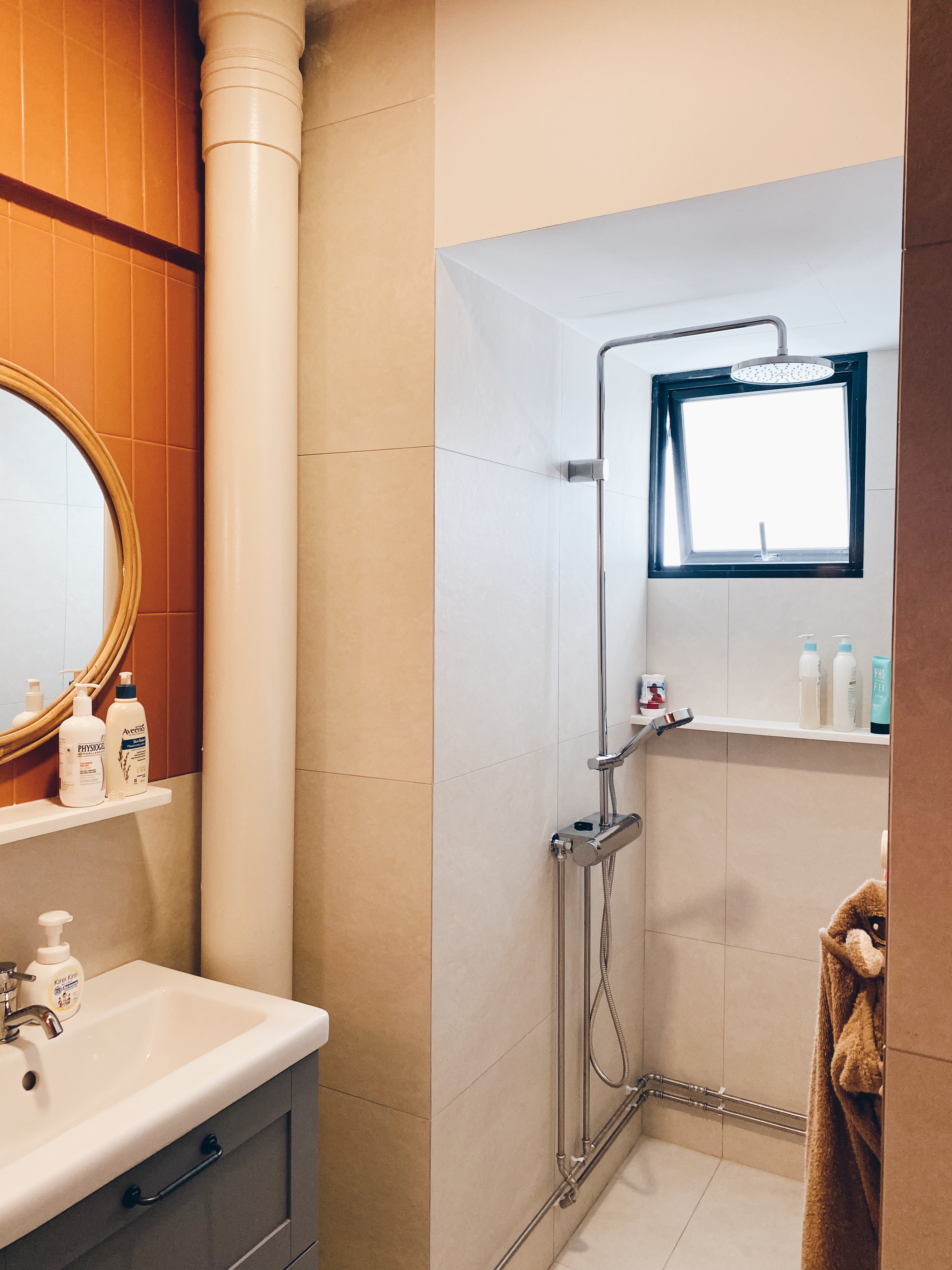 Our Bathrooms and their Personalities - Bathroom vanity, white sink, silver faucet, mirror, orange tiles, beige walls