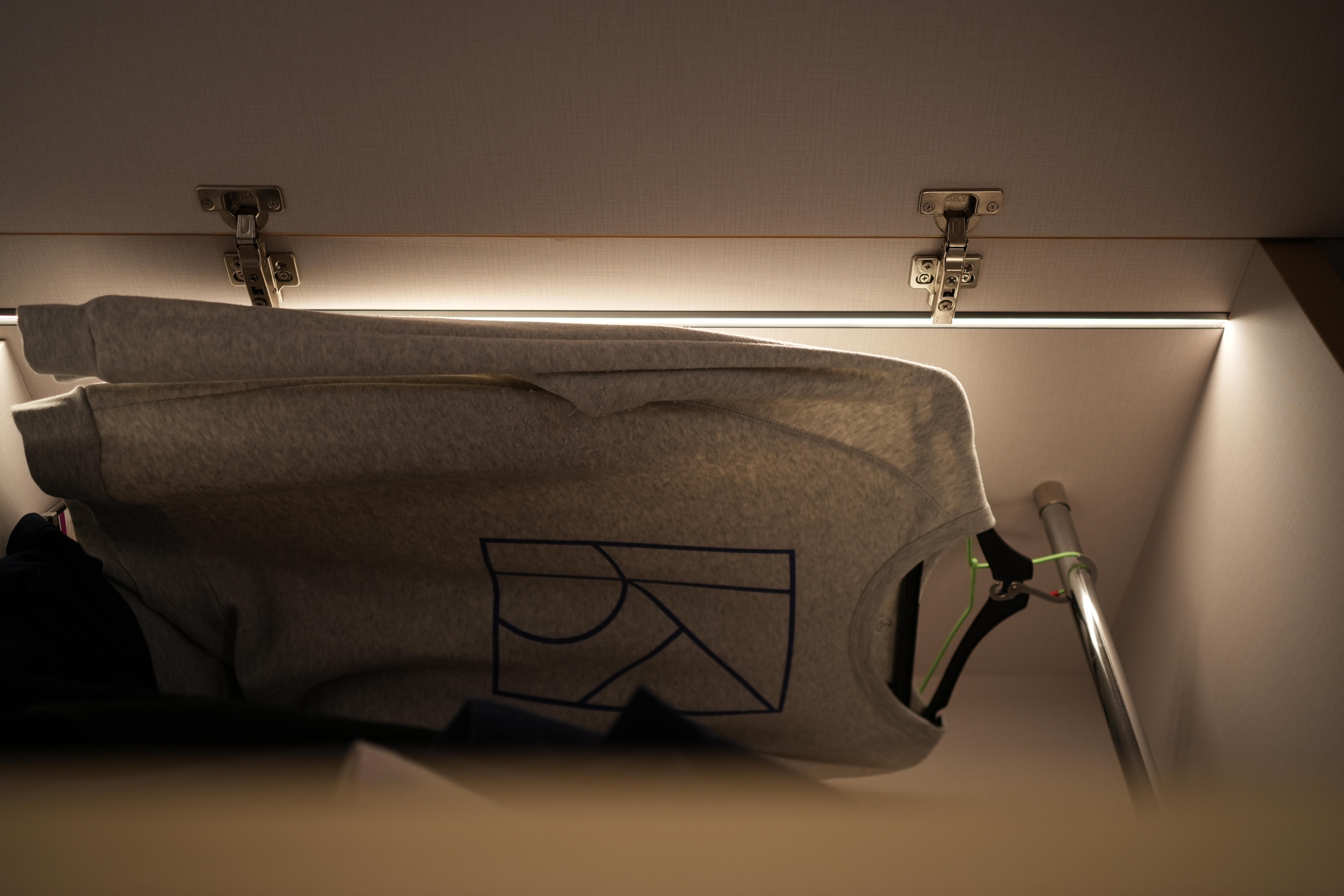 Choosing Lighting: Dimmables, Accents, Moods - gray hoodie, hanging, closet, soft lighting, fabric texture, modern design