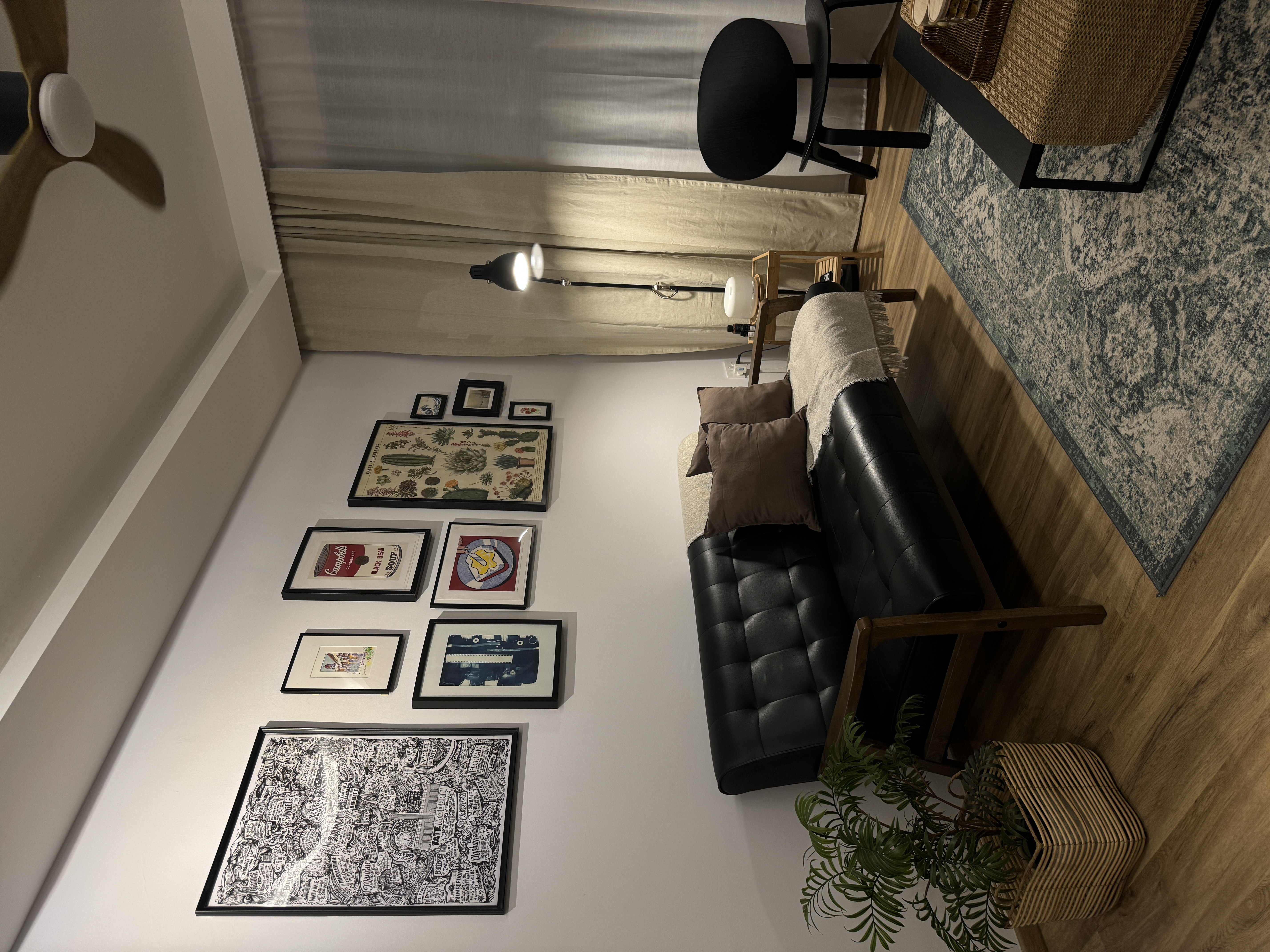 A characterful living room - modern living room, cozy corner, black leather sofa, beige throw blanket, wooden floor