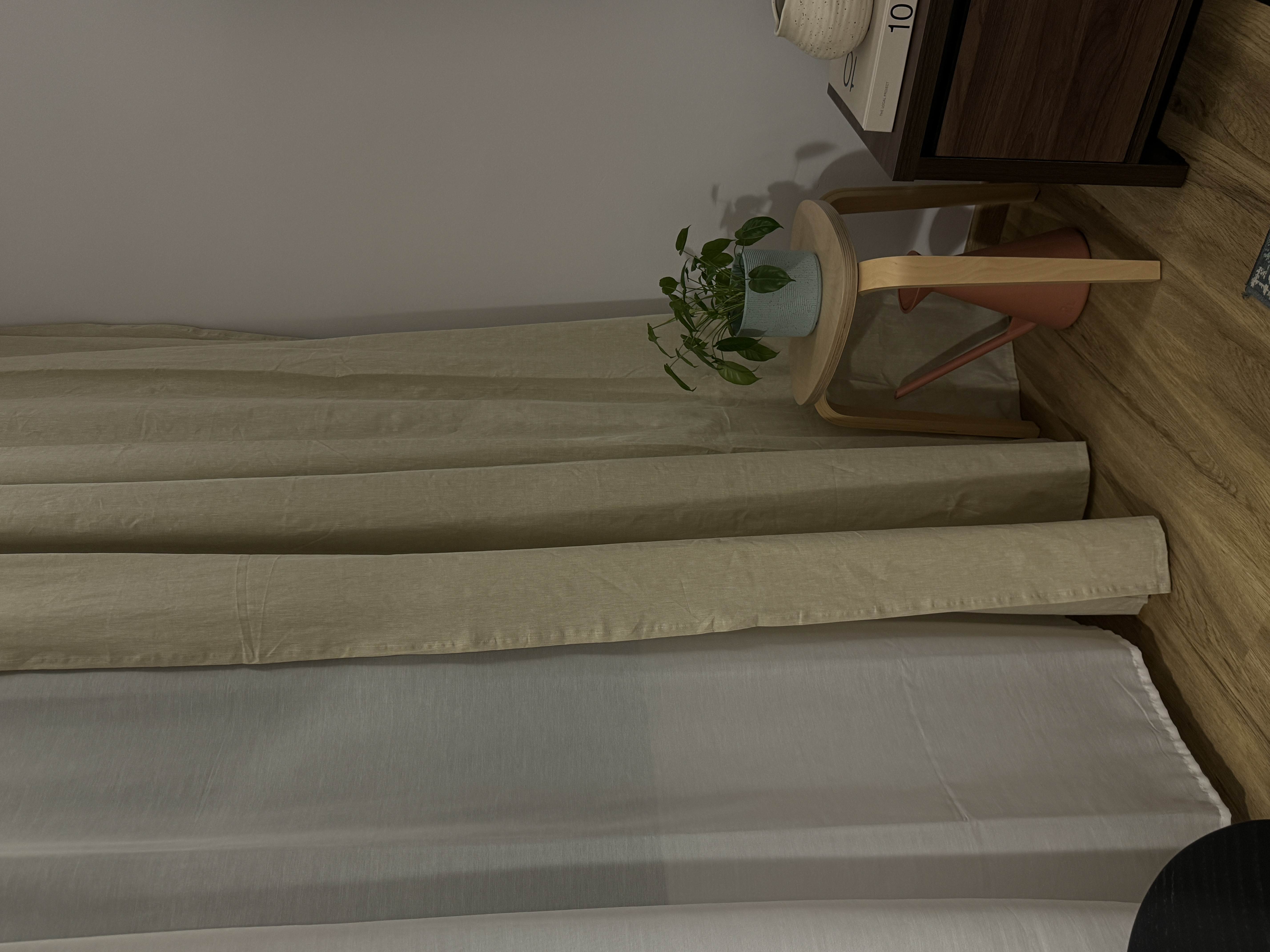 A characterful living room - Minimalist bedroom with wooden furniture and soft beige bedding., Potted plant with green leaves